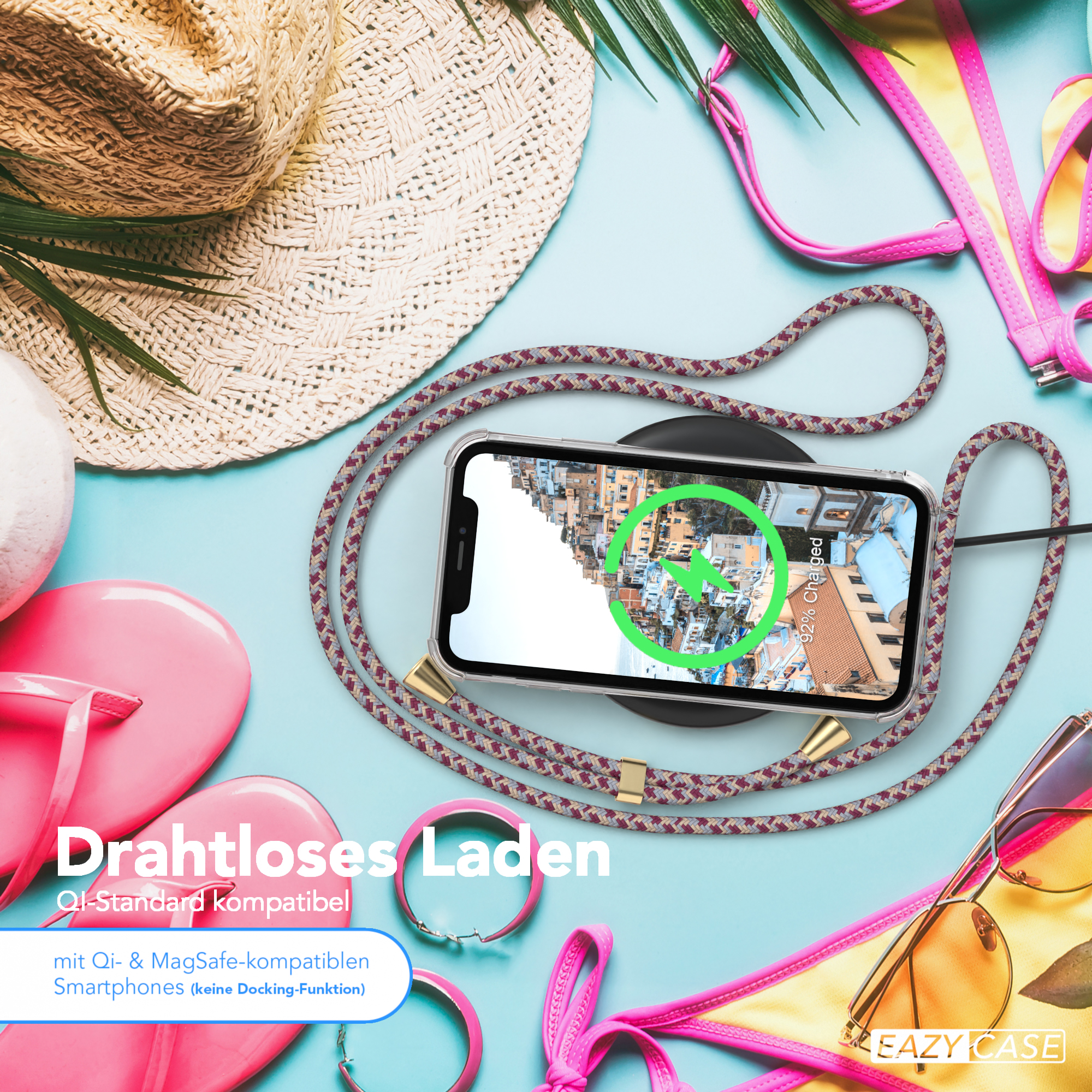 Telefon, das auf einem kabellosen Ladegerät geladen wird, mit anderen Strandartikeln. Text überlagert.