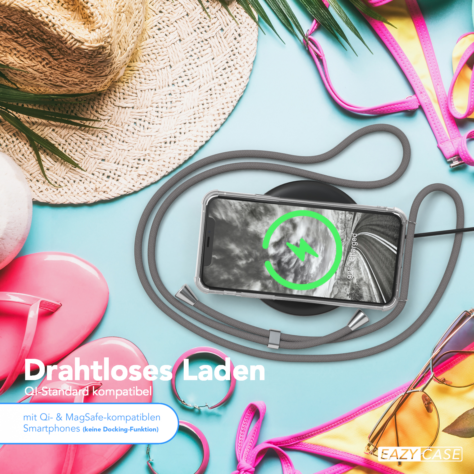 Telefon mit Hülle und Riemen auf blauem Untergrund mit Zubehör. Strandthema mit Strohhut und Sonnenbrille.