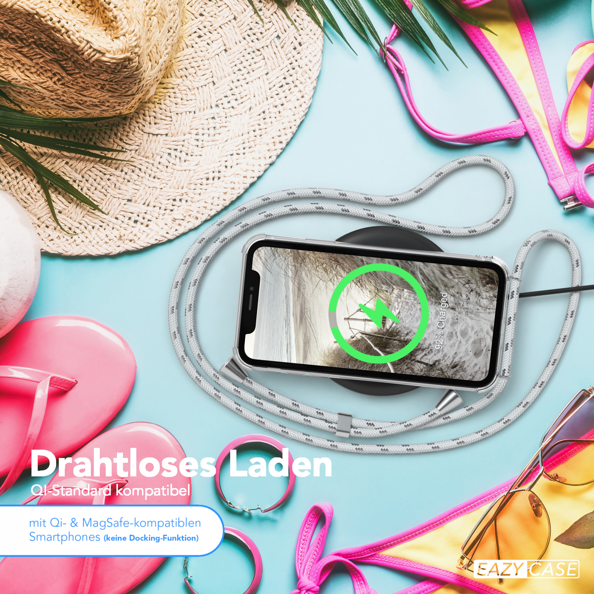 Ein Telefon wird drahtlos auf einem Pad aufgeladen. Strandaccessoires, Hut, Sonnenbrille und Flip-Flops.