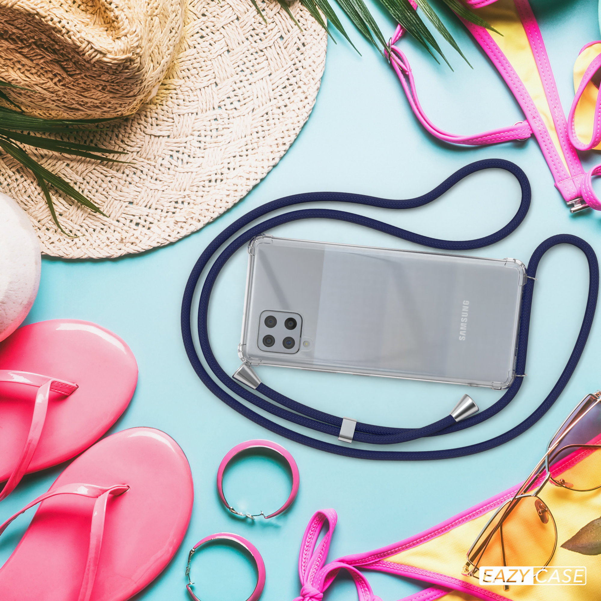 Telefon mit Band und Accessoires auf blauer Fläche. Strandthema.