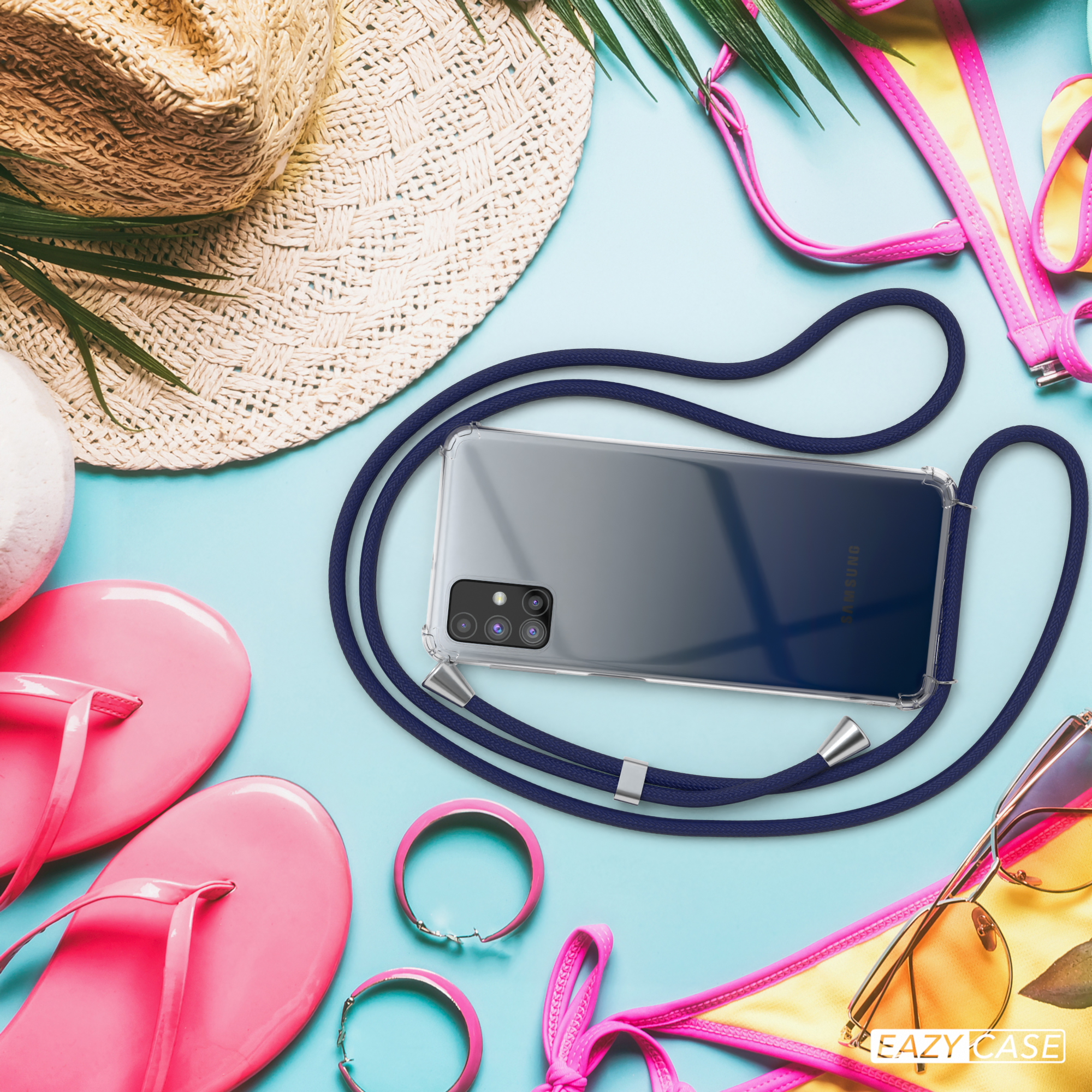 Ein Handy mit blauem Band am Strand, neben Strohhut, rosa Flip-Flops und Sonnenbrille.