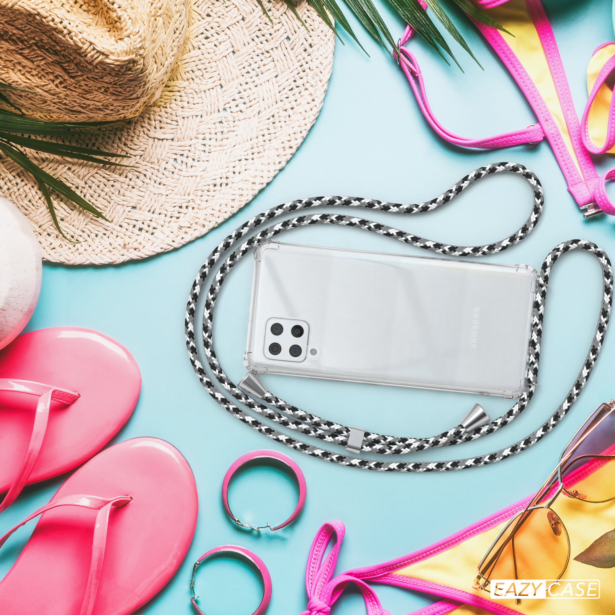 Telefon mit Riemen, Sonnenbrille, Flip-Flops und Hut auf blauer Oberfläche angeordnet.