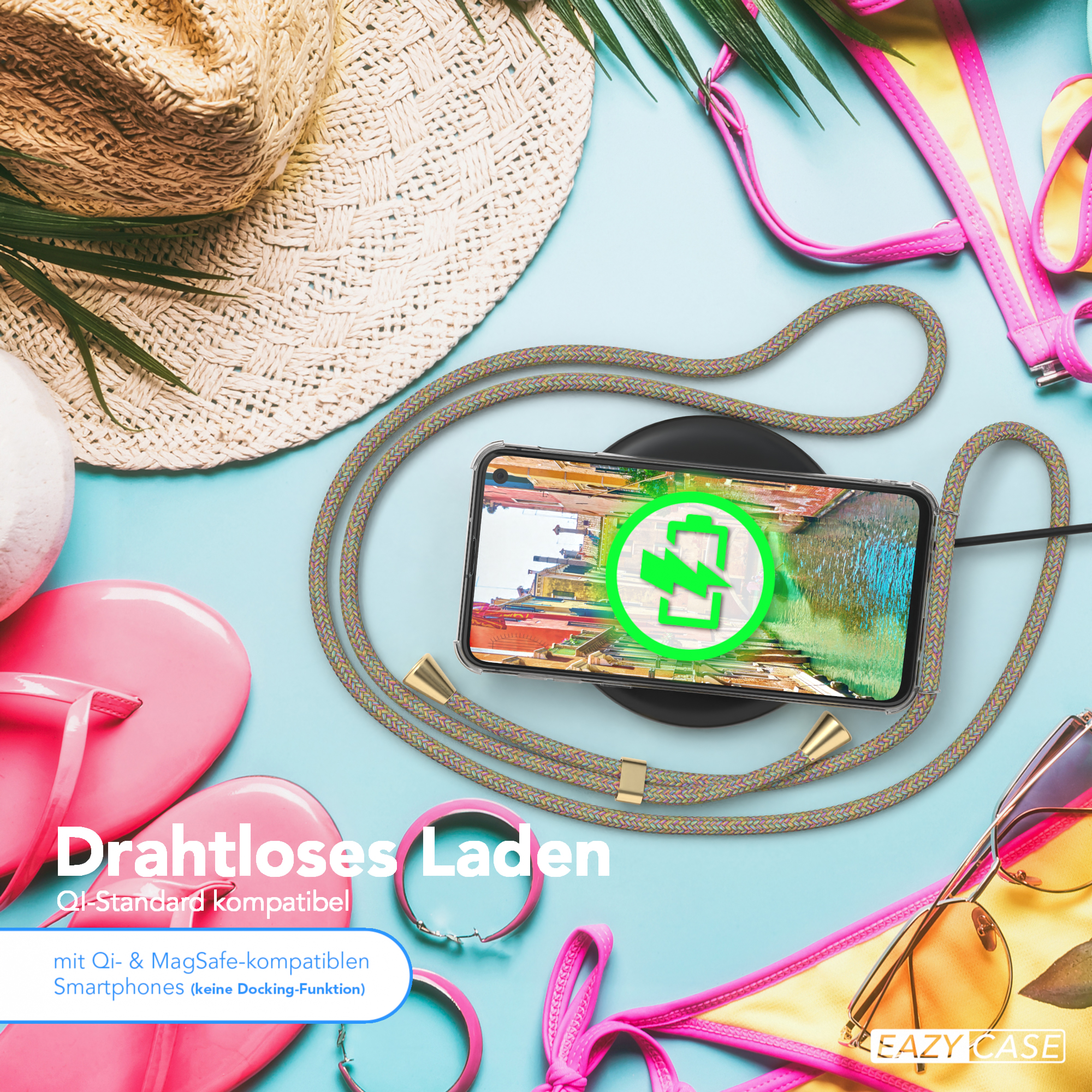 Handyhülle mit Riemen auf einem Qi-Ladegerät, Strandaccessoires und Bikini-Oberteil auf hellblauem Untergrund.