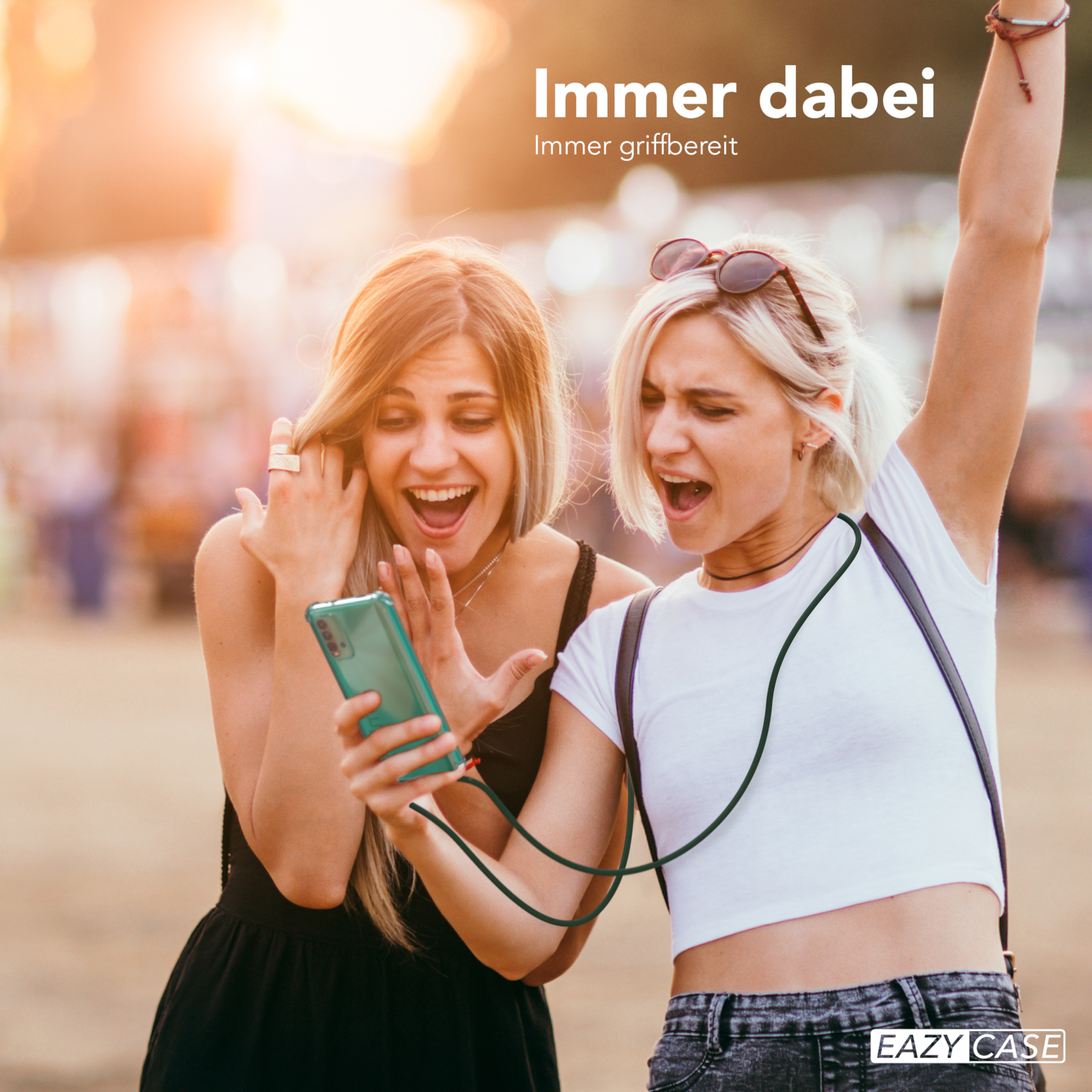 Zwei Frauen betrachten ein Telefon, beide mit offenem Mund. Eine hebt aufgeregt den Arm. Szene hat einen verschwommenen Hintergrund.