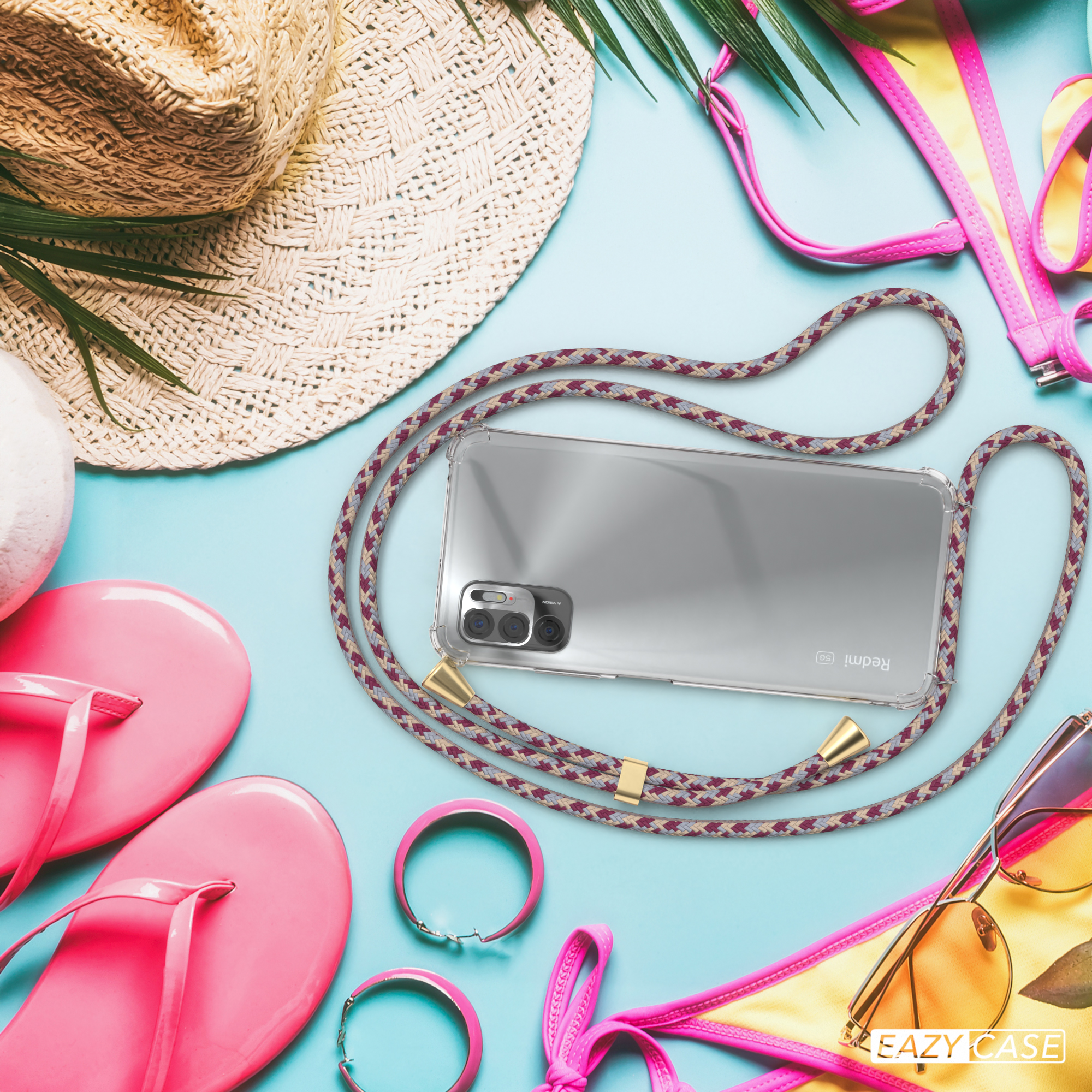 Telefon mit Lanyard auf blauem Untergrund mit Strandutensilien: Hut, Sonnenbrille, rosa Flip-Flops und Zubehör.