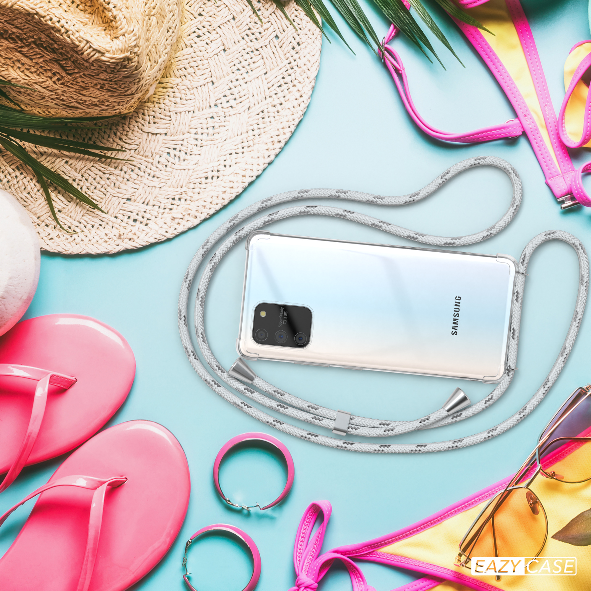 Handyhülle mit grauem Band, neben Strandaccessoires wie Sonnenbrille und Hut.
