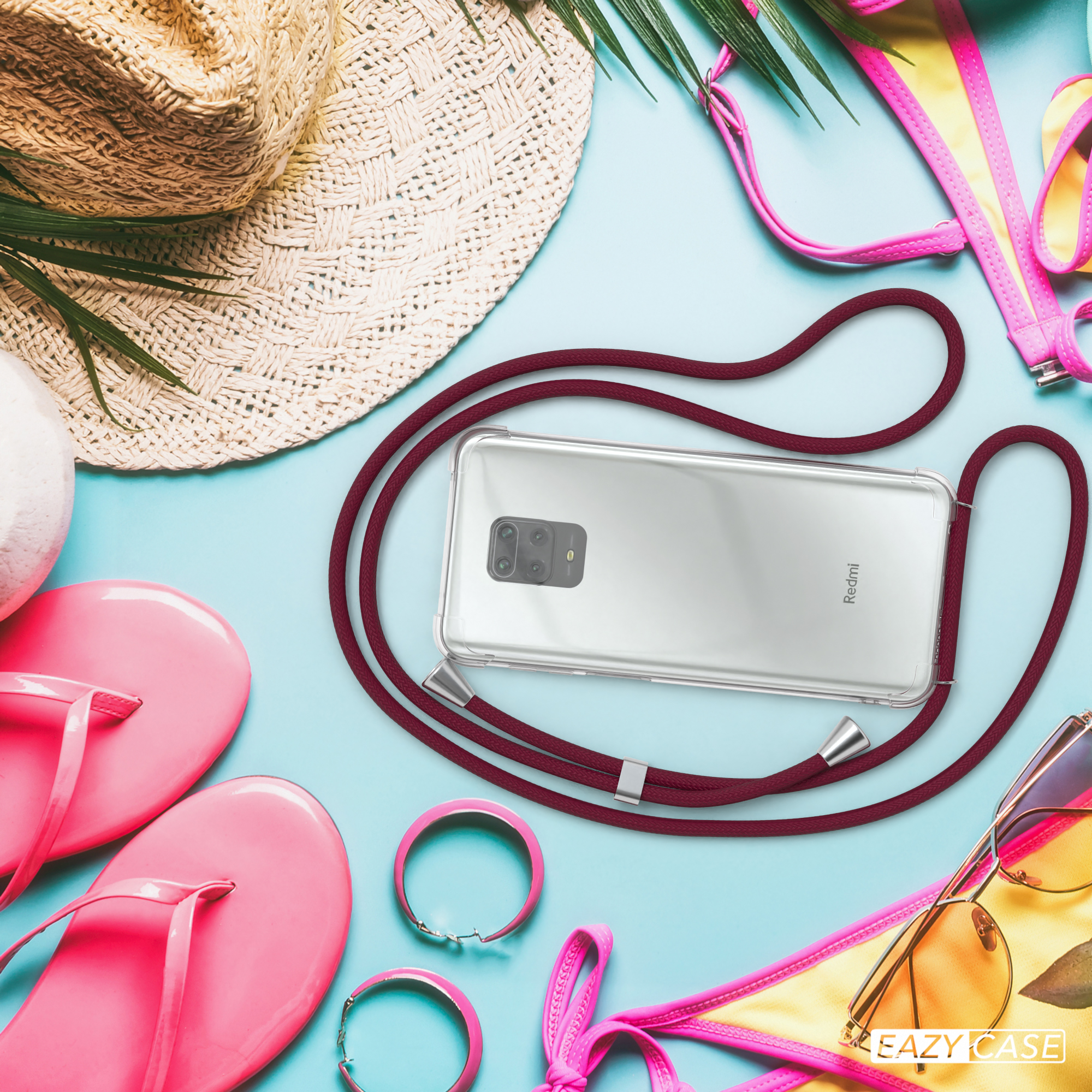 Telefon mit Lanyard, Strandkulisse. Strohhut, rosa Flip-Flops, Bikini, Sonnenbrille. Handyhülle mit rotem Lanyard.