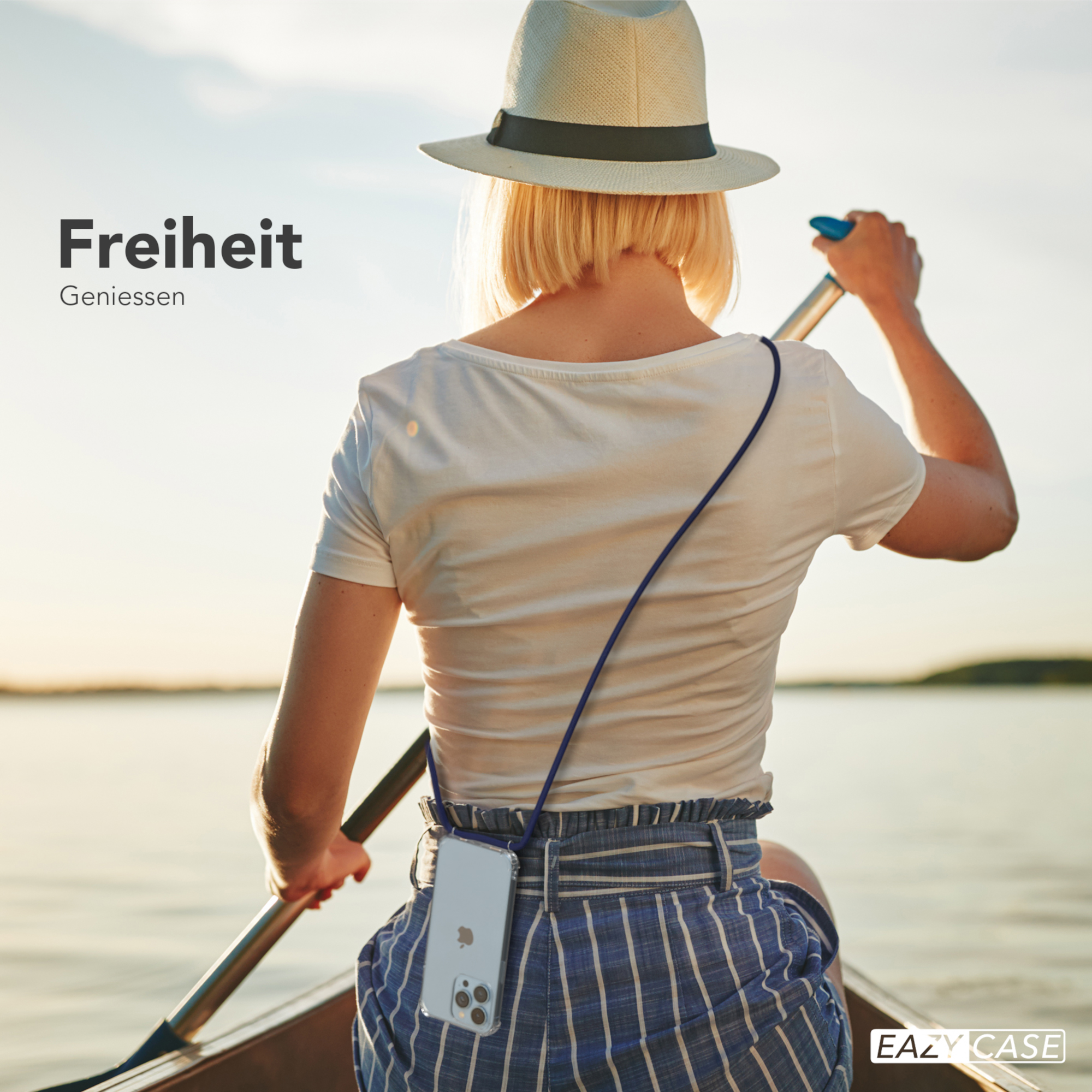 Frau paddelt auf einem See, Telefon hängt an einem blauen Umhängeband. Rückansicht.