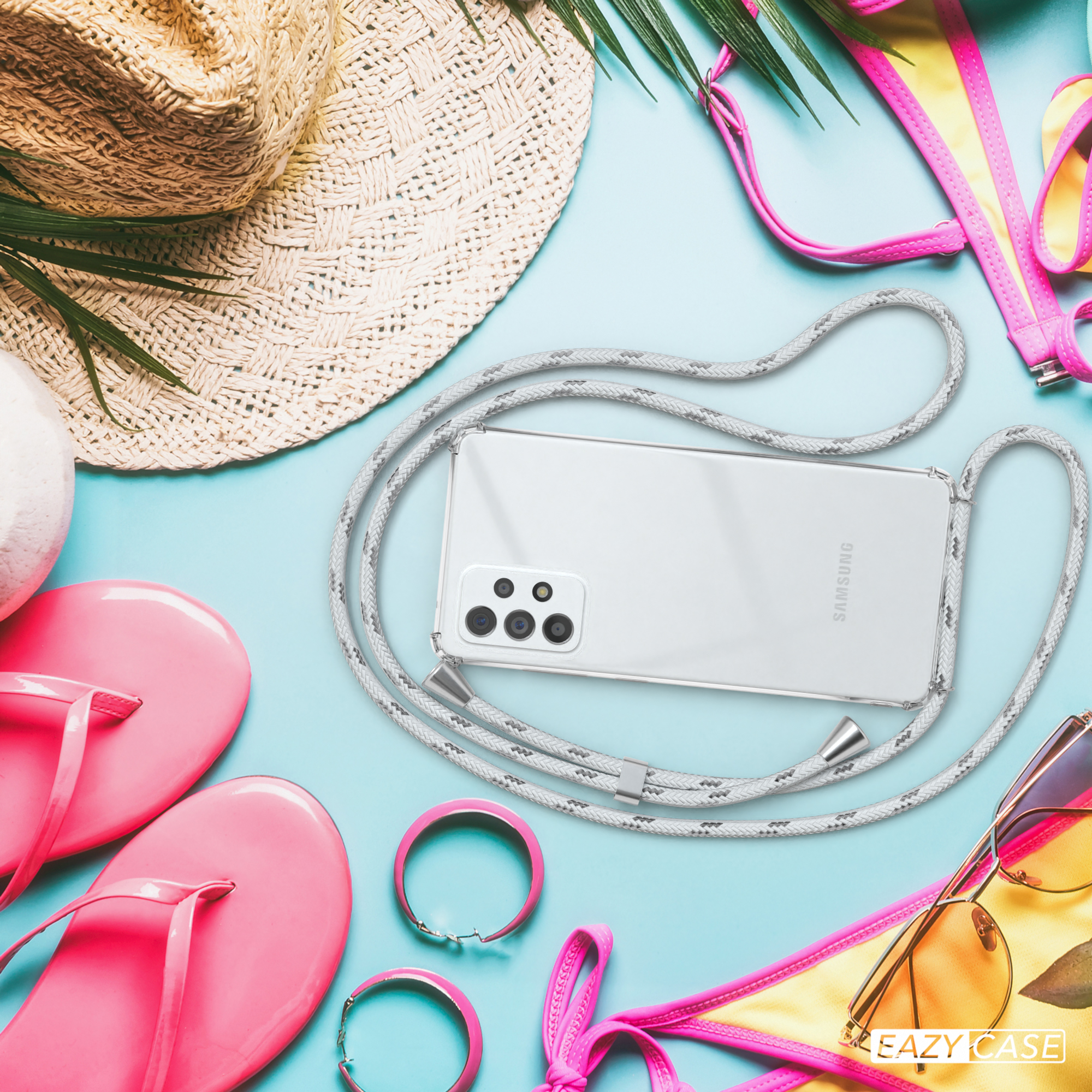 Strandszene. Telefon mit Lanyard, Flip-Flops, Hut, Sonnenbrille, Bikini-Oberteil und Armband.