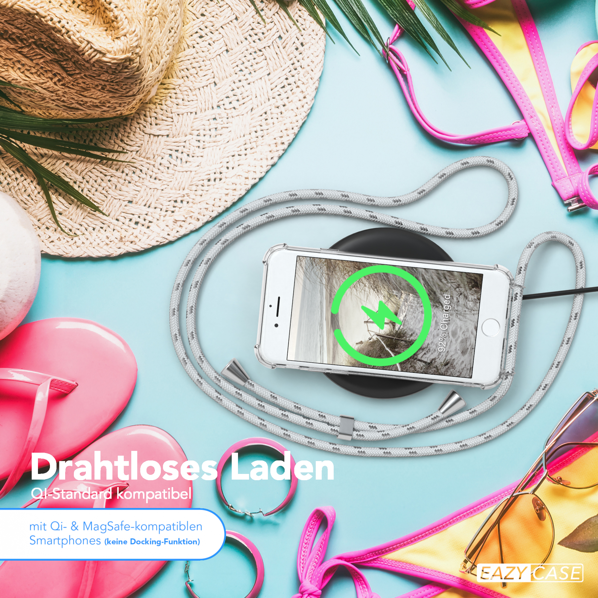 Telefon wird drahtlos geladen. Strandaccessoires im Hintergrund.