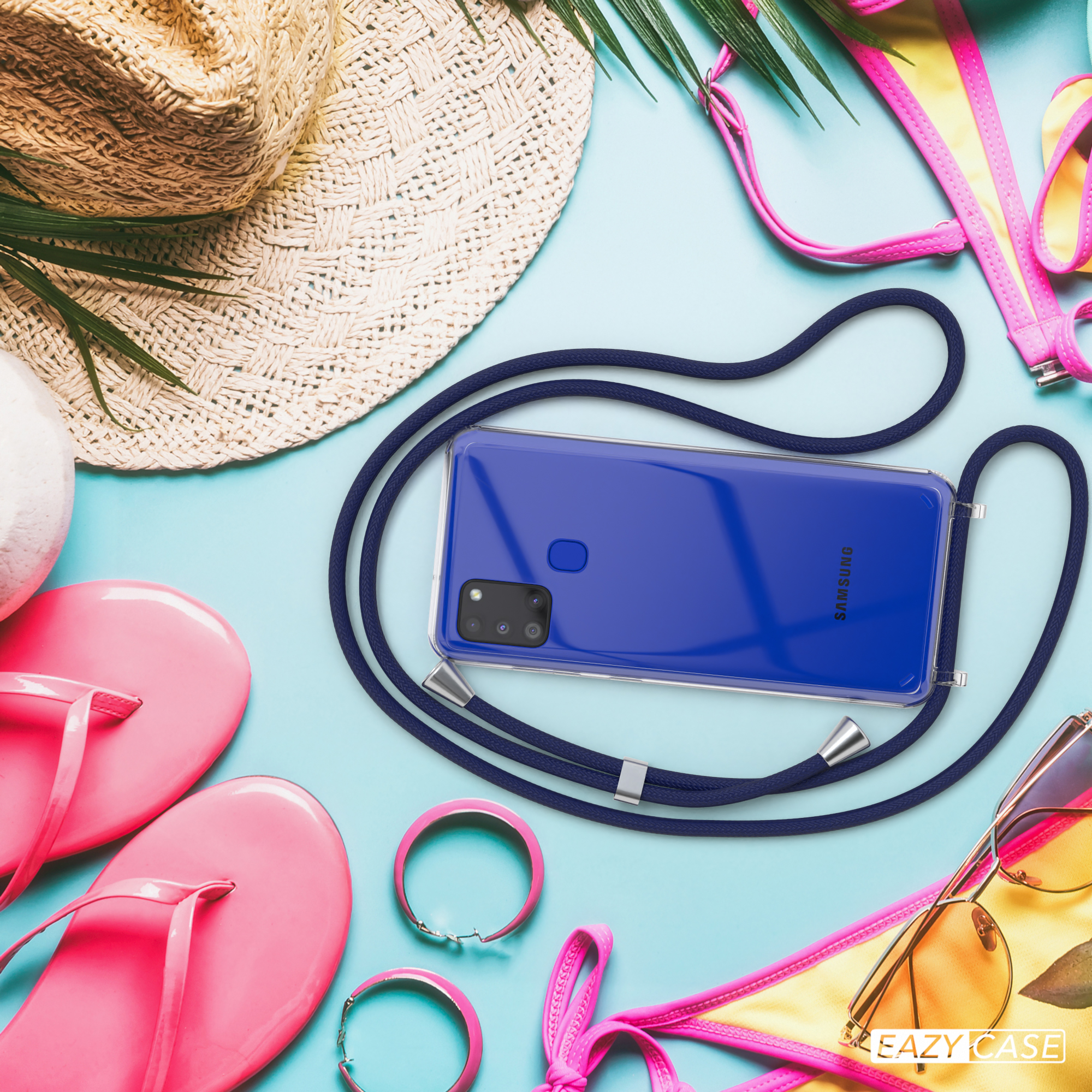 Ein Telefon mit dunkelblauem Kabel und blauem Gehäuse liegt auf einer hellblauen Oberfläche. Es gibt rosa Zubehör.