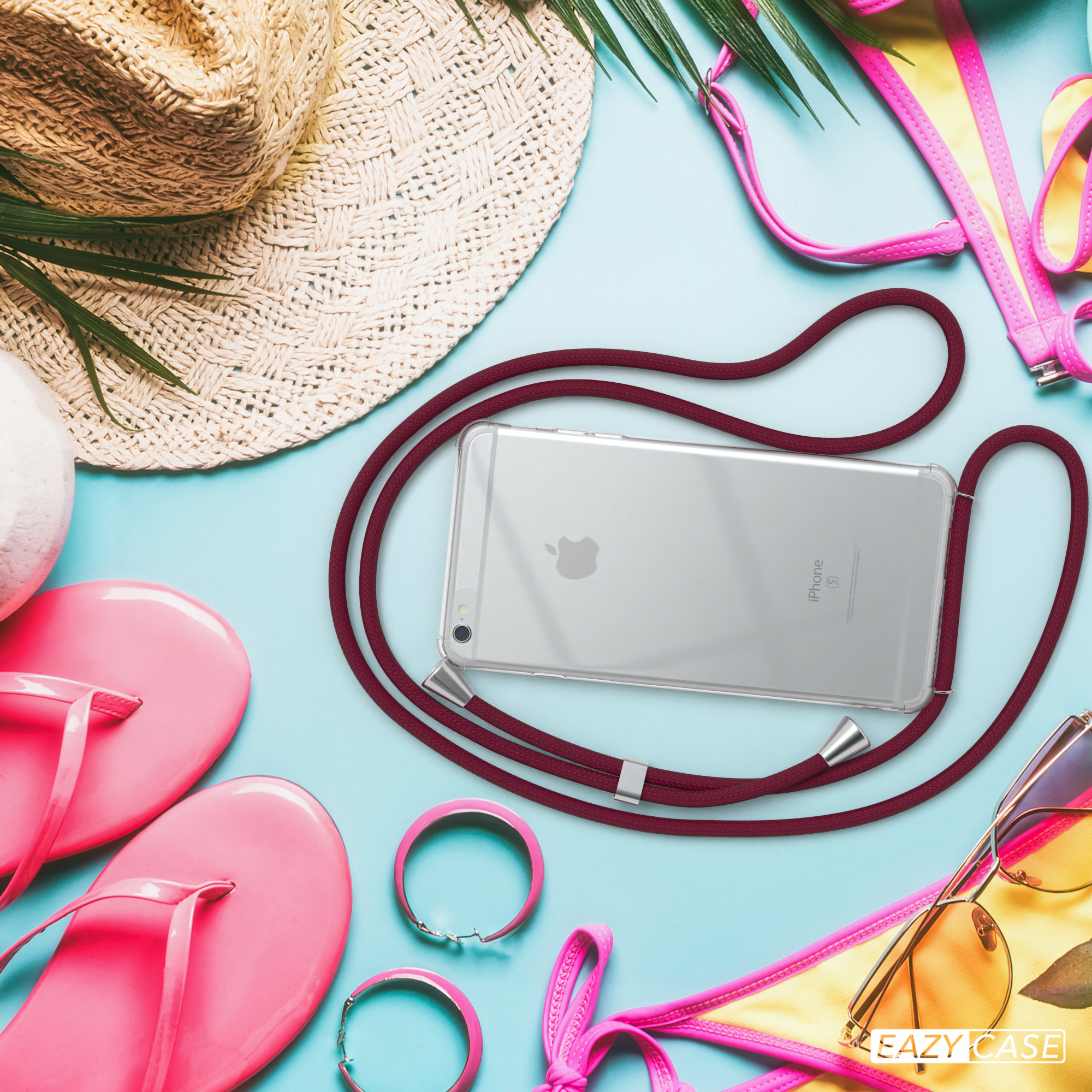 Ein Telefon mit roter Kordel und Strandutensilien. Die Szene hat rosa, gelbe und blaue Farben.