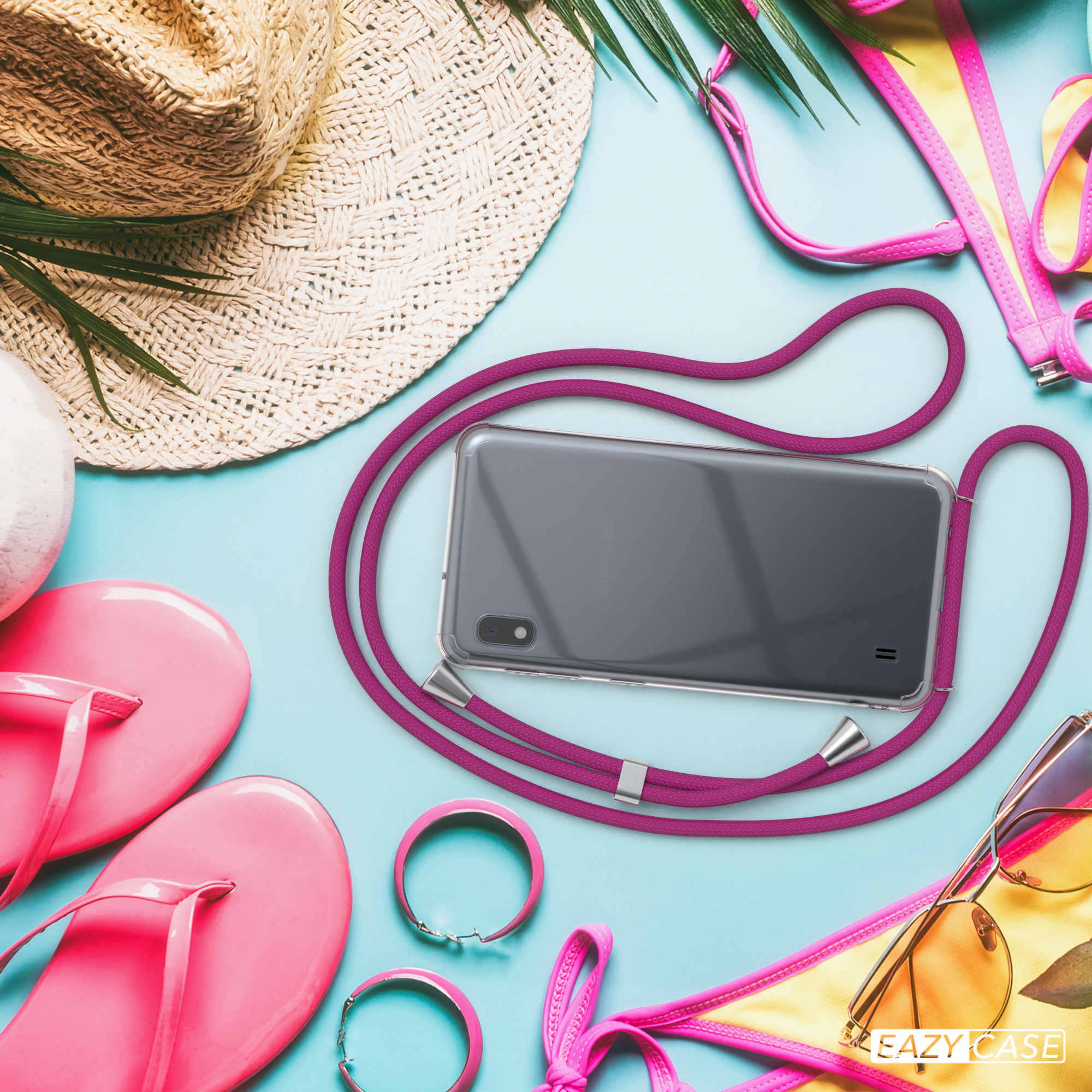 Telefon mit magentafarbenem Lanyard. Strandaccessoires im Hintergrund.