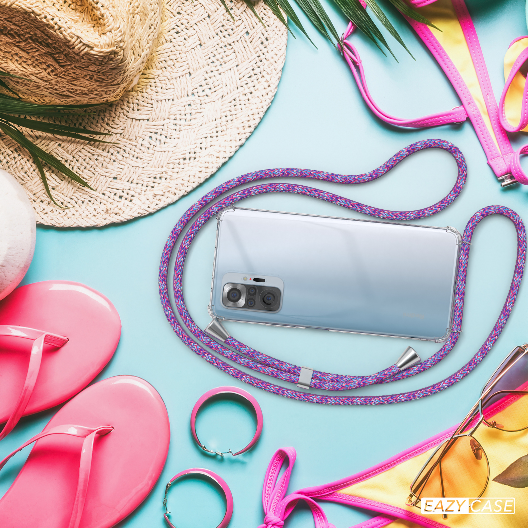 Telefon mit Lanyard auf blauem Untergrund mit Zubehör. Strandthema: Hut, Sandalen, Bikini und Sonnenbrille.