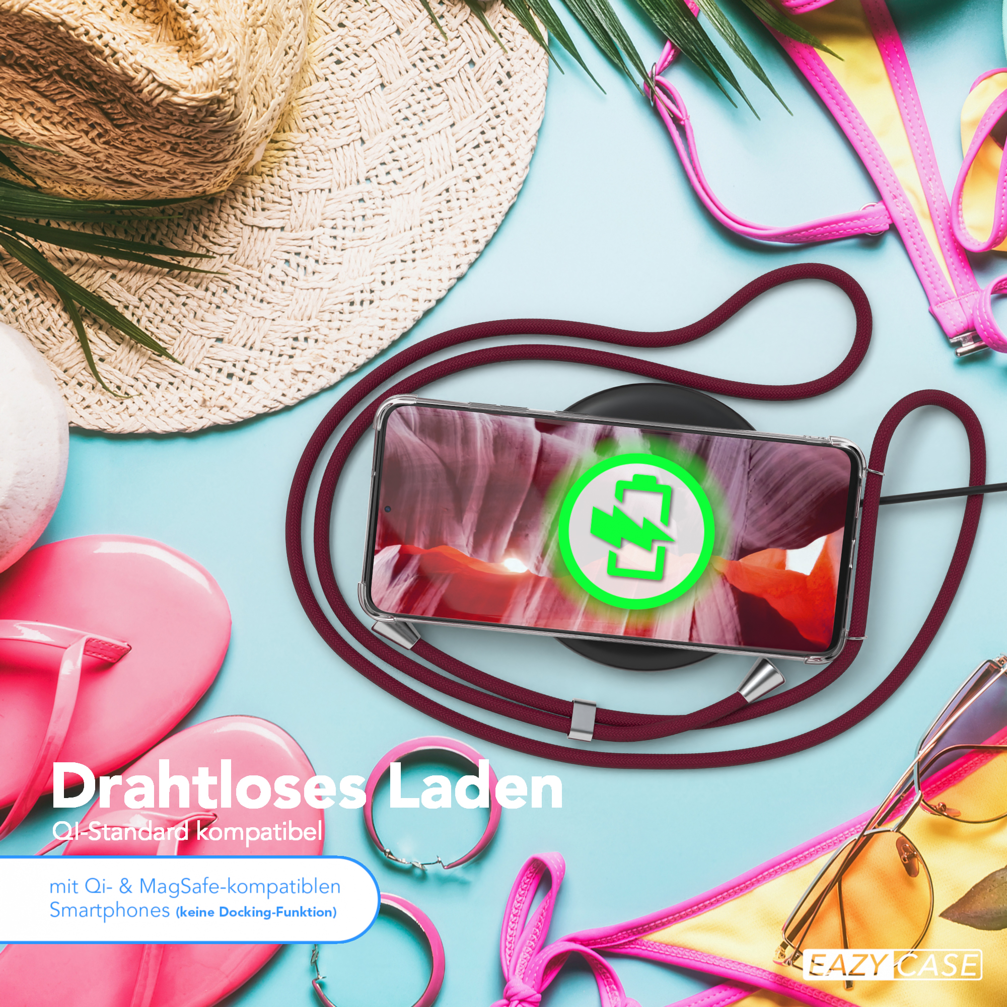 Telefon lädt kabellos, Strandaccessoires im Hintergrund.