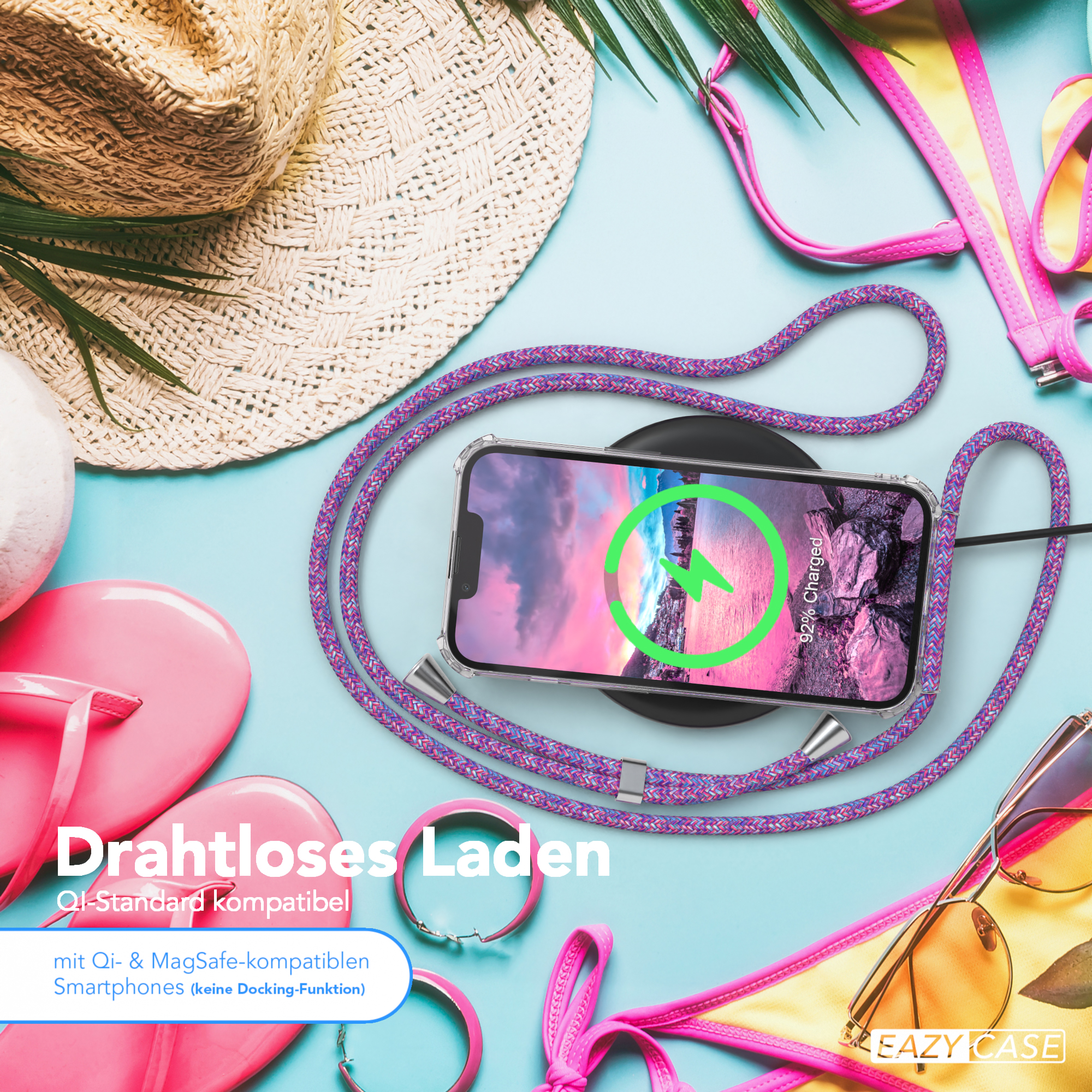 Strandszene mit drahtlosem Laden, pinkfarbenen Accessoires und anderen Strandartikeln.