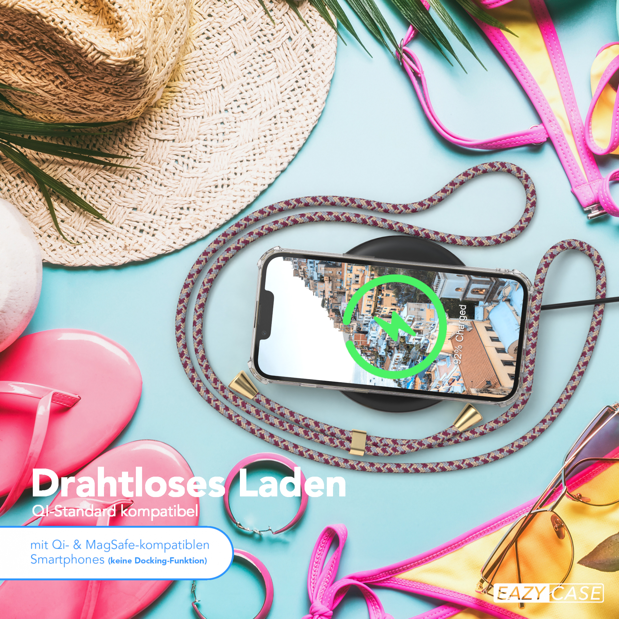 Draufsicht auf Telefon auf Ladegerät, pinkfarbene Accessoires und Sonnenbrille. Blauer Hintergrund, gelber Bikini.
