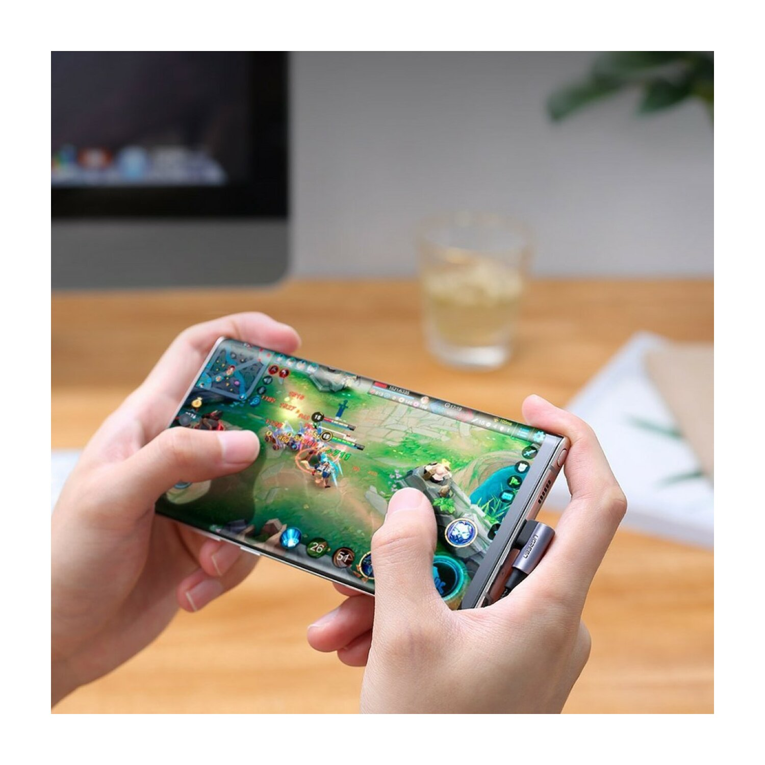 Dłonie trzymające telefon, grające w grę mobilną ze szczegółami.