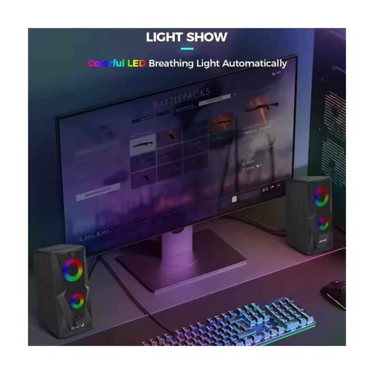 Una configuración de ordenador con monitor, altavoces con luces de colores, teclado y escritorio.