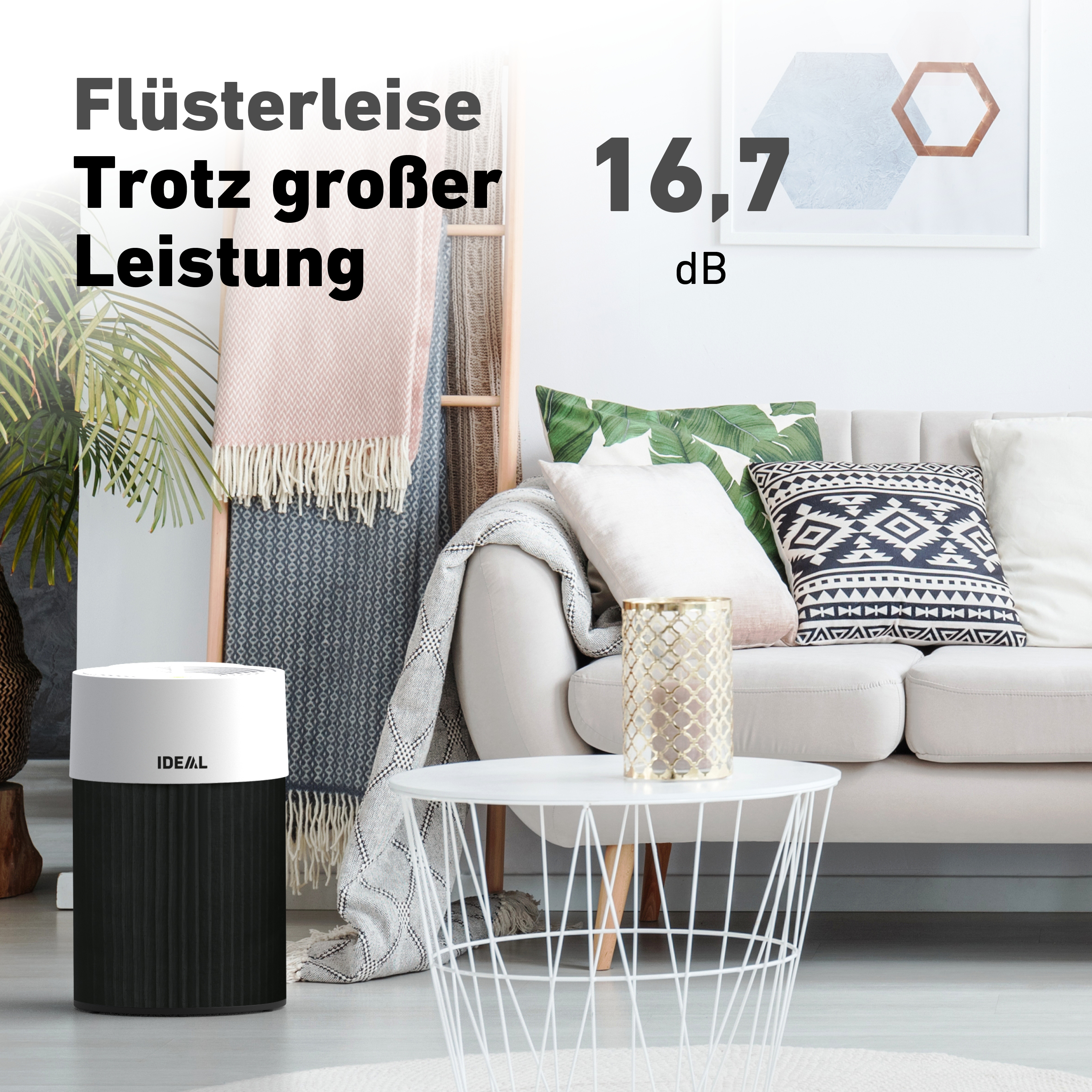 Luftreiniger, Sofa und Beistelltisch in einem Raum. Der Text auf dem Bild lautet: 'Flüsterleise'.