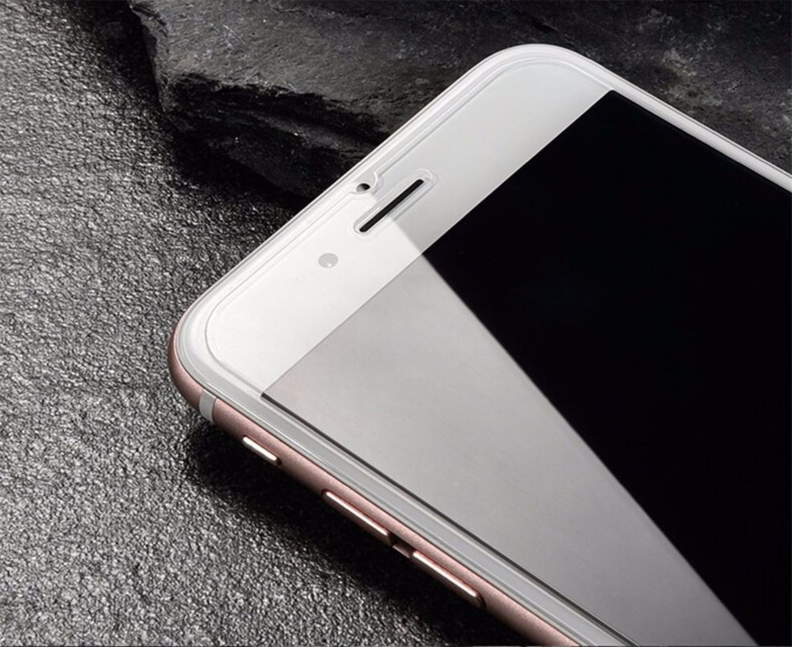 Nahaufnahme eines roségoldenen iPhones mit schwarzem Bildschirm auf einer dunklen, strukturierten Oberfläche.