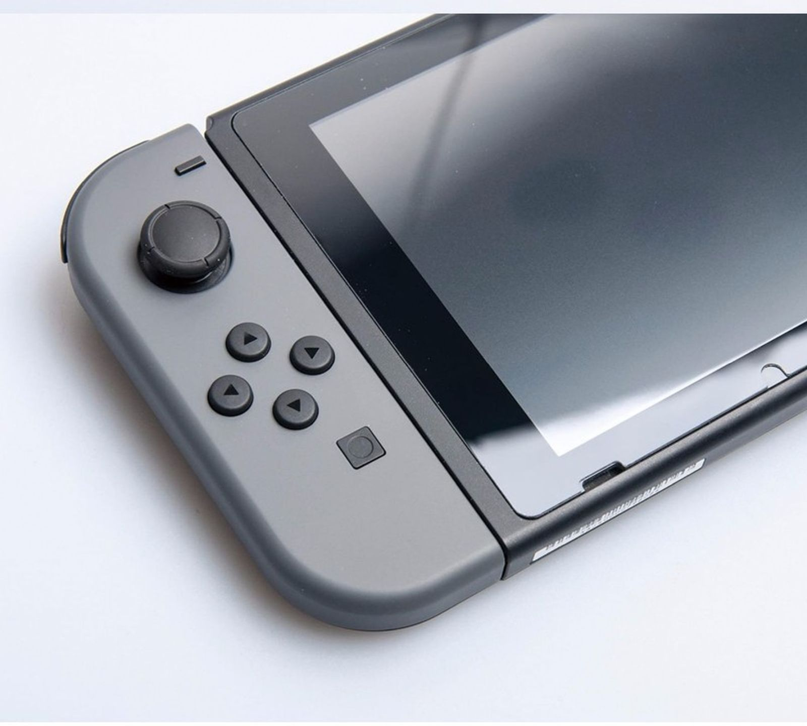 Ein grauer Spielekonsolen-Controller mit schwarzem Stick und Knöpfen.