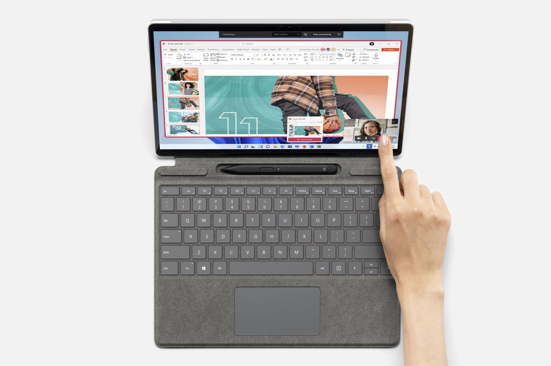 Laptop, aperto, mostra una videochiamata con una donna, una mano tocca lo schermo e la tastiera.
