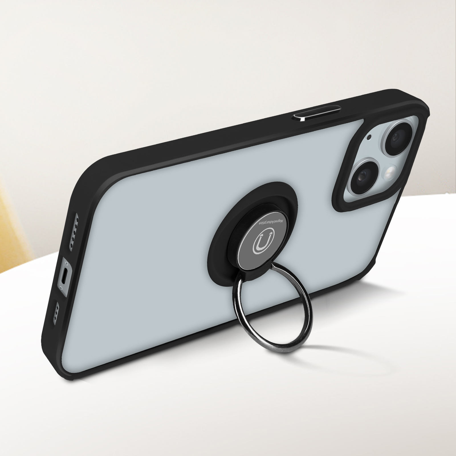 Uno smartphone in una custodia azzurra con un supporto ad anello nero sul retro, appoggiato su una superficie bianca.