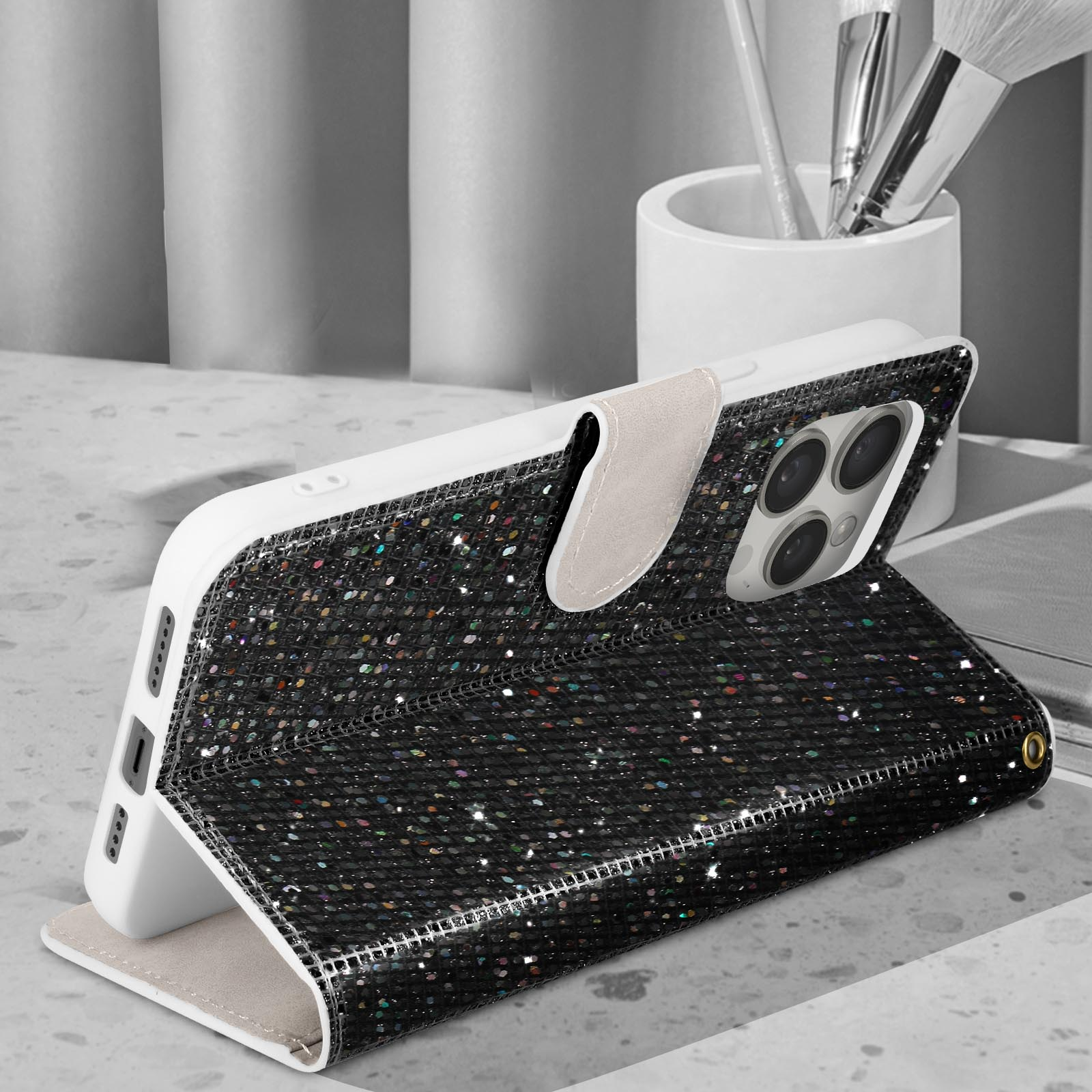 Coque de téléphone noire à paillettes, téléphone blanc, sur surface, fond blanc.