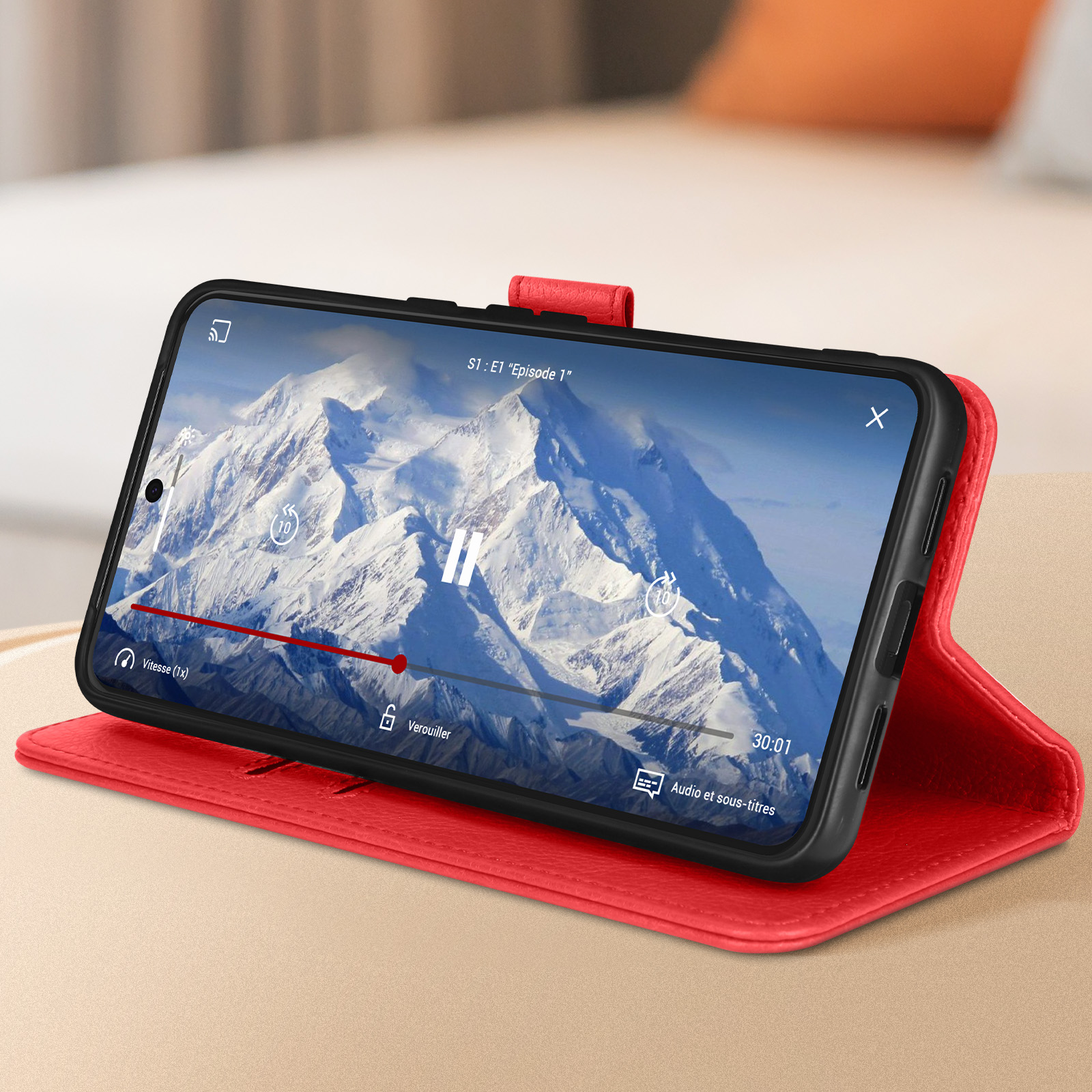 Smartphone che mostra un film con sottotitoli all'interno di una custodia rossa.