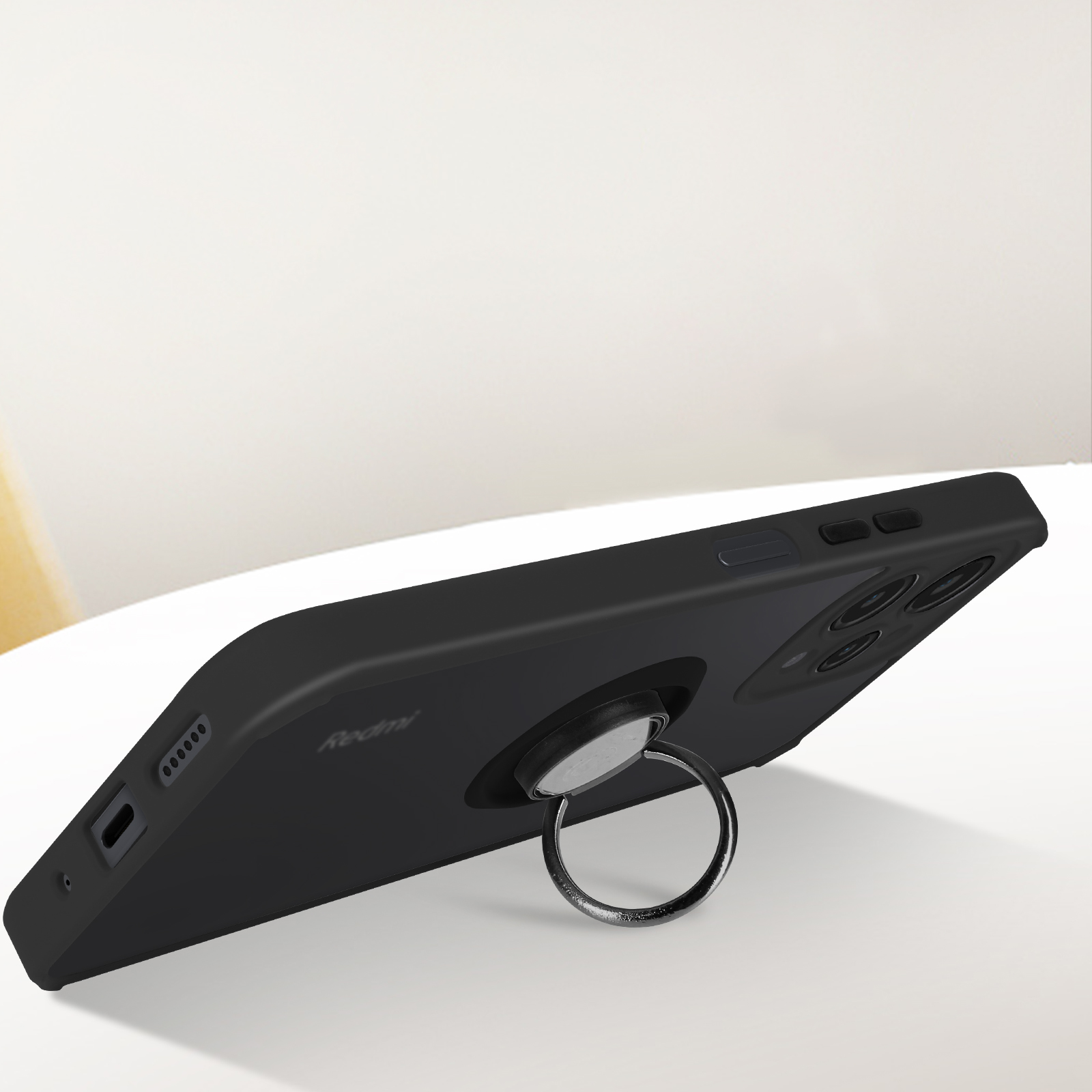 Telefono nero con un supporto ad anello. Il telefono è su una superficie bianca. Sfondo bianco.