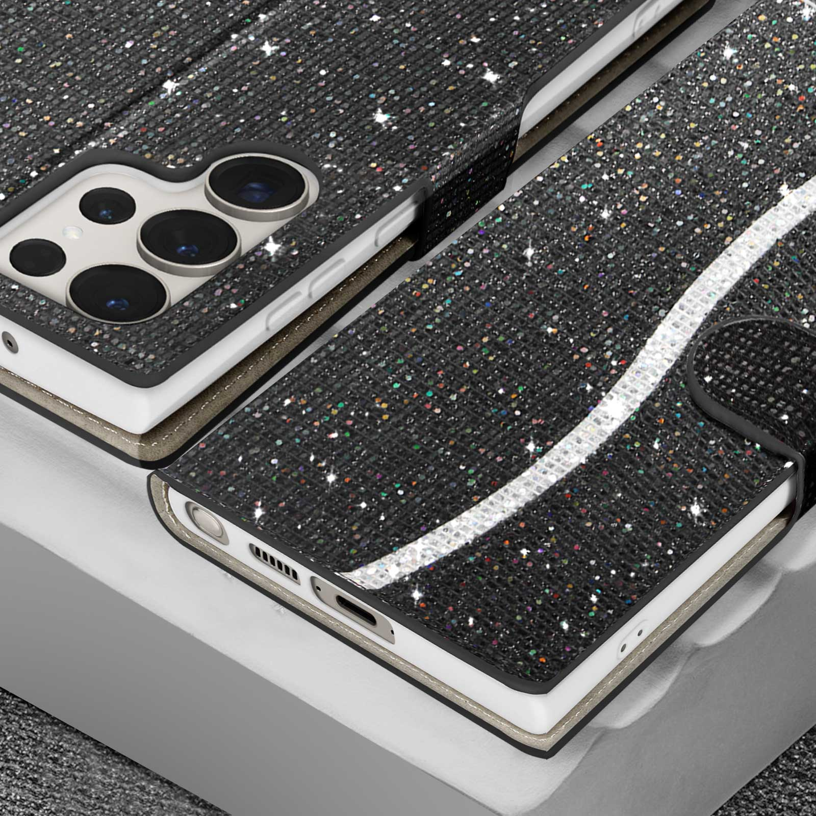 Custodia nera con paillettes in un supporto, con telefono dentro, su superficie argentata.