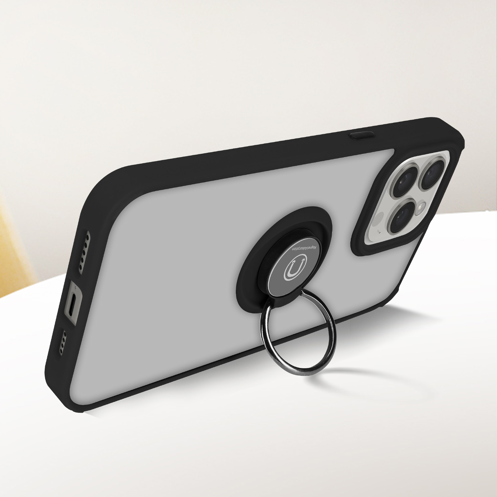 Un telefono con custodia nera, un supporto ad anello e una superficie bianca.