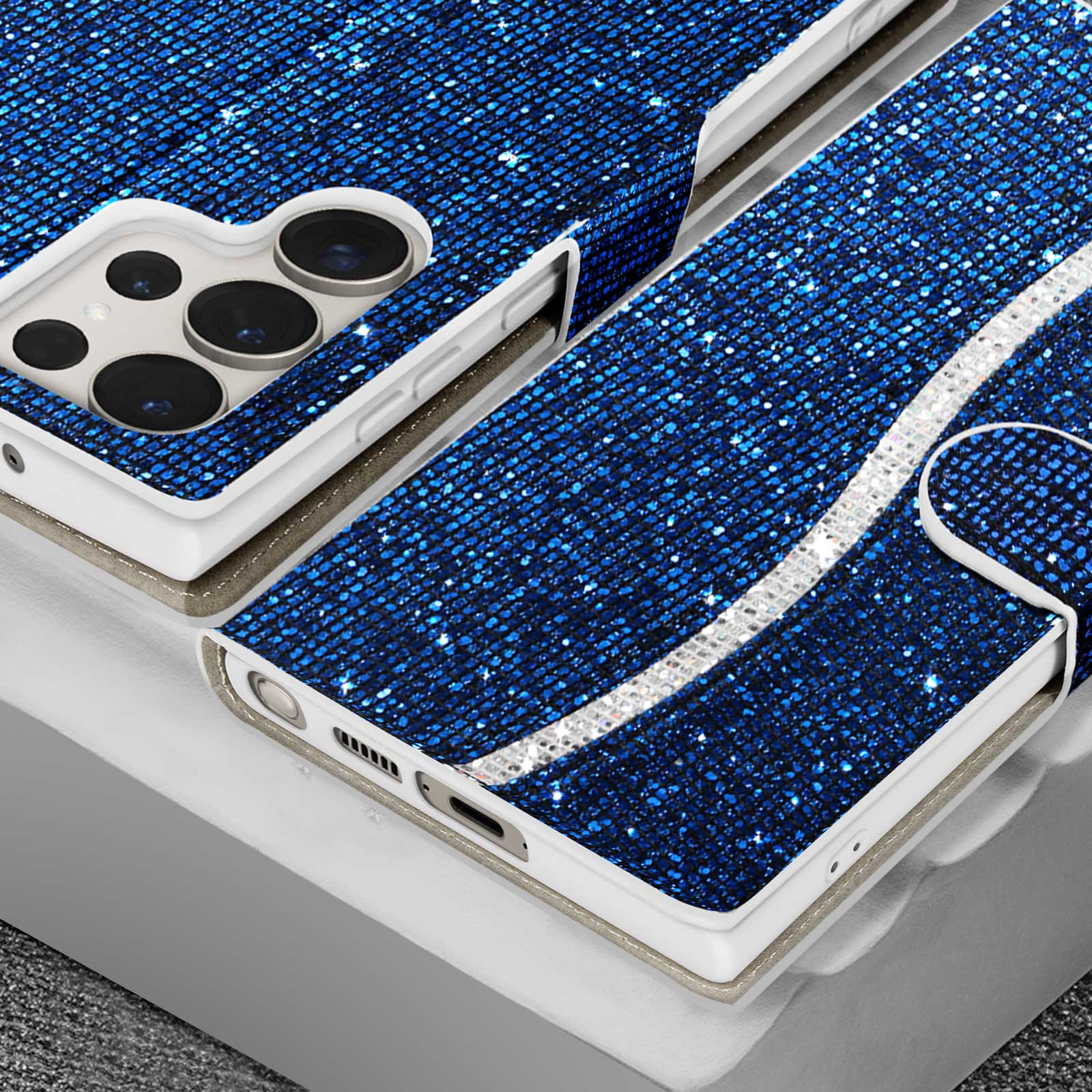 Primo piano di una custodia per telefono blu con paillettes, aperta, con interno bianco e striscia argentata.