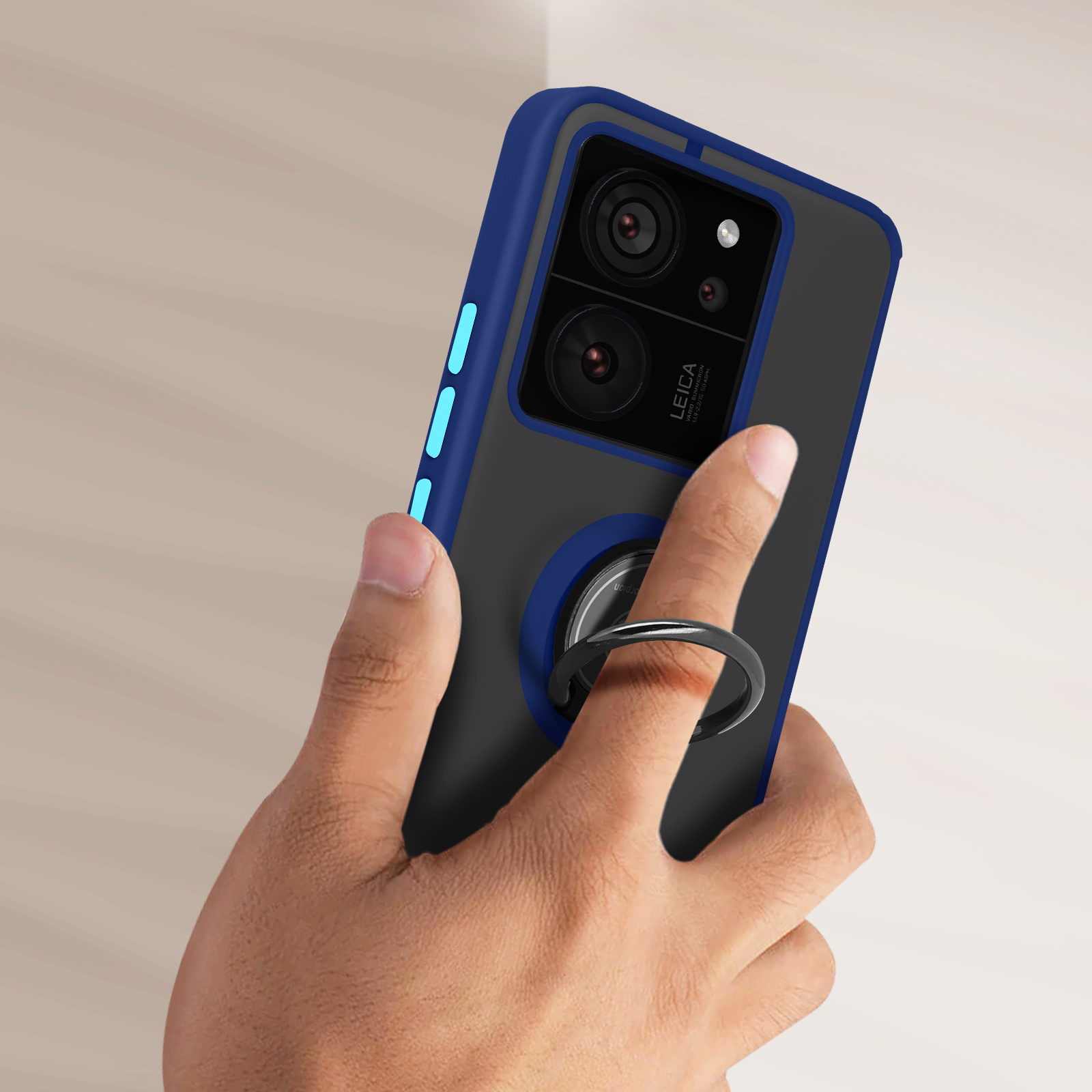 Een hand die een blauw-zwarte telefoonhoes vasthoudt. Een ring is bevestigd.