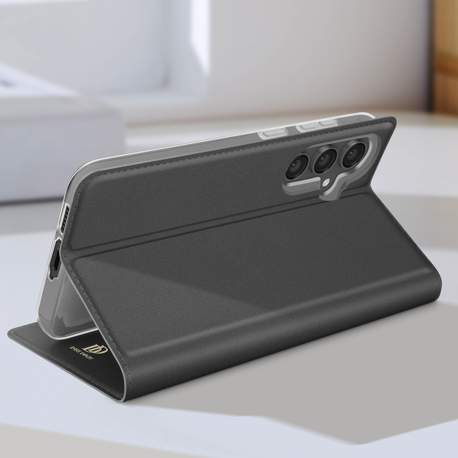Custodia per telefono nera, aperta con un telefono. Il telefono ha tre fotocamere.