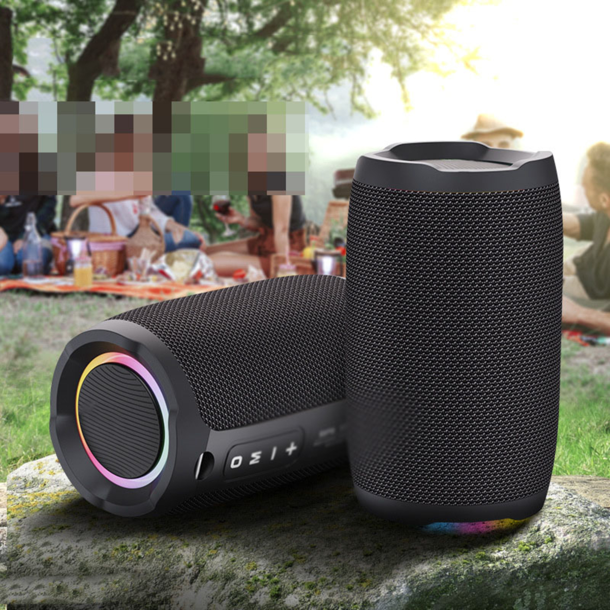 Zwei schwarze zylindrische Lautsprecher mit bunten Ringlichtern. Outdoor-Einstellung, Personen im Hintergrund.