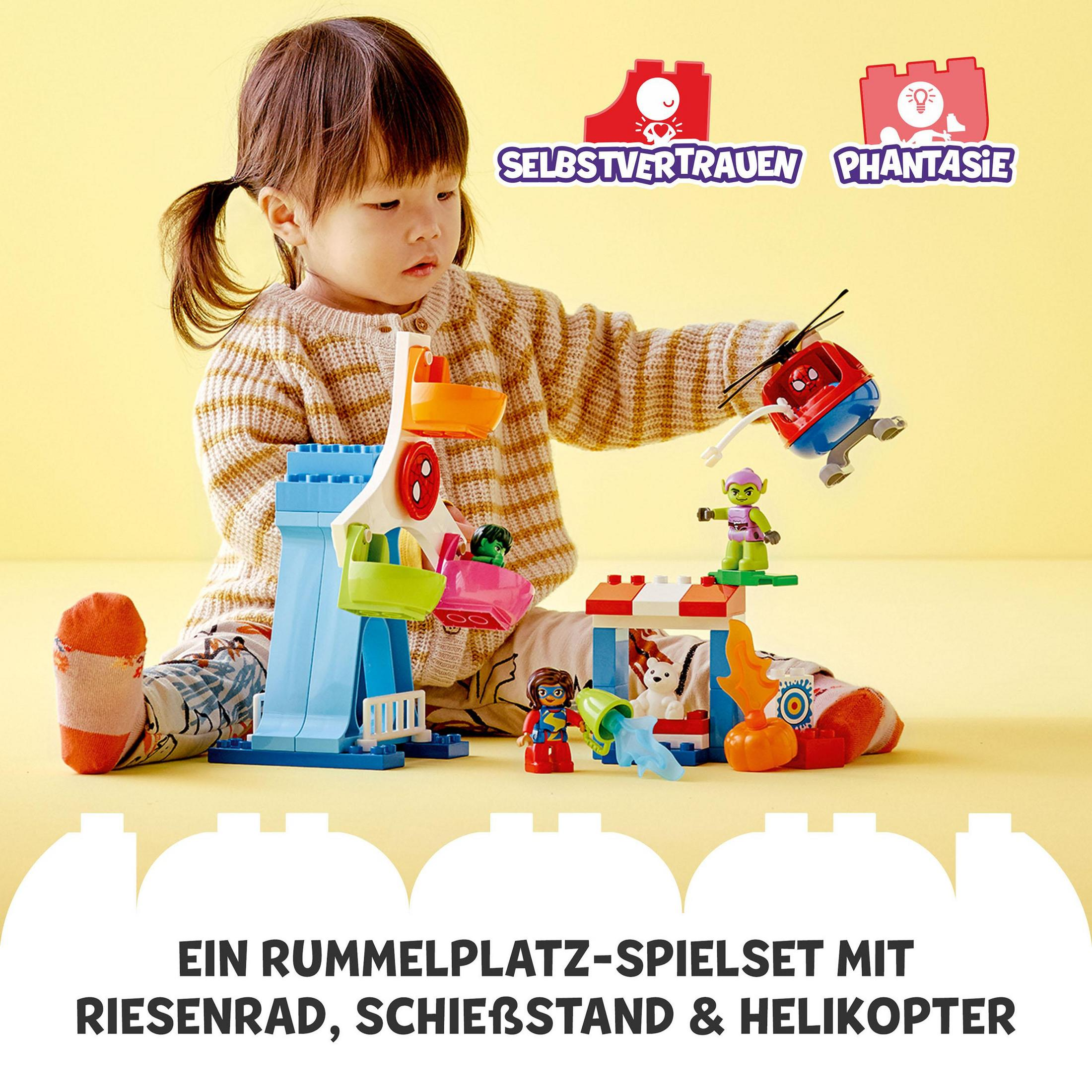 Ein Kind spielt mit LEGO Duplo Spielzeug. Das Set enthält ein Riesenrad, ein Karussell und andere bunte Elemente.