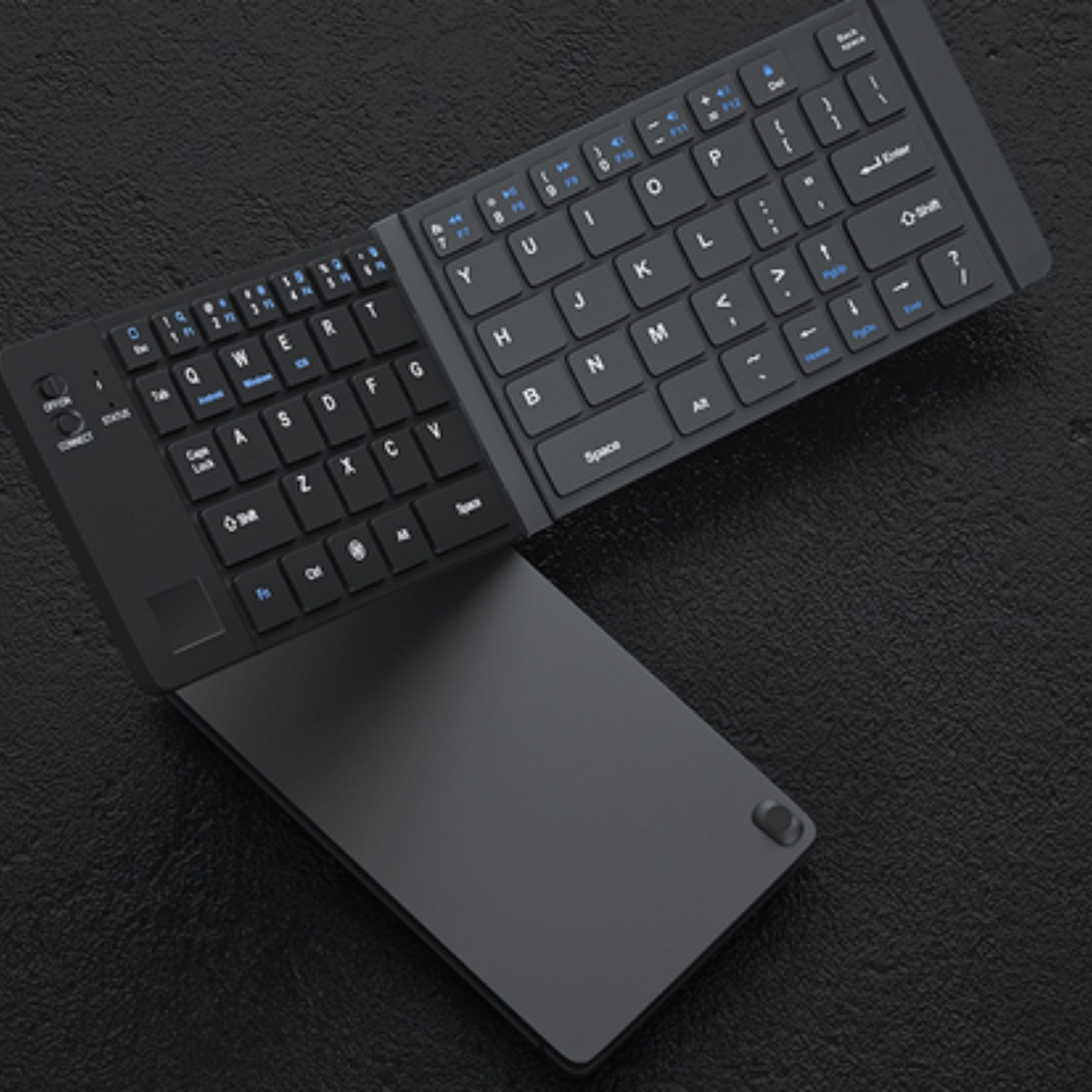 Schwarze, faltbare Tastatur, ausgeklappt. Die Tastatur liegt auf dunkler Oberfläche.