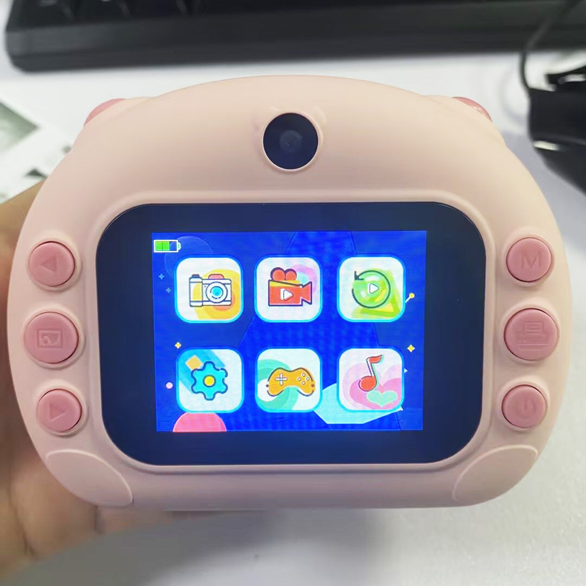Cámara digital rosa para niños con pantalla LCD. El fondo está borroso.