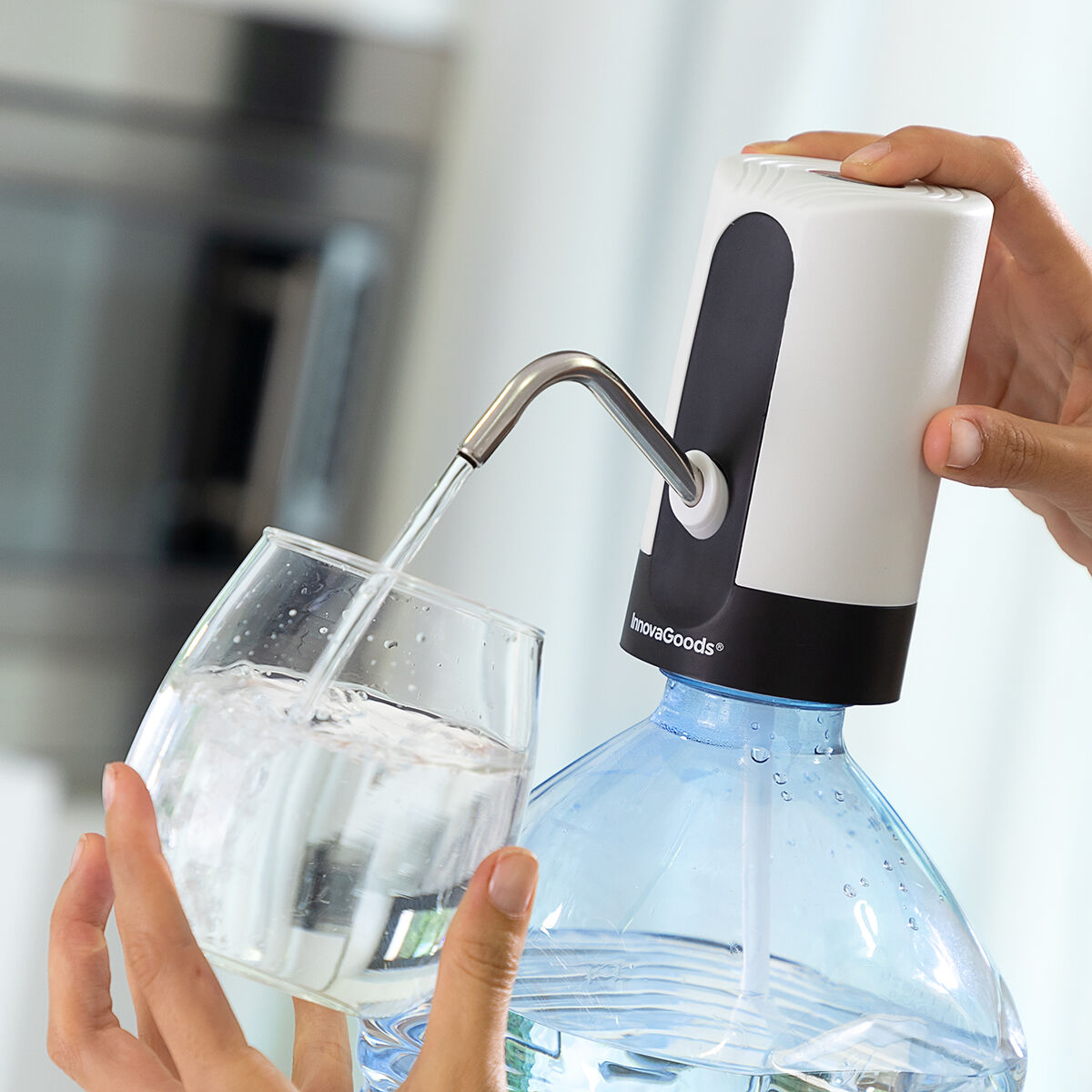 Una mano versa l'acqua da una bottiglia in un bicchiere. L'acqua è limpida.