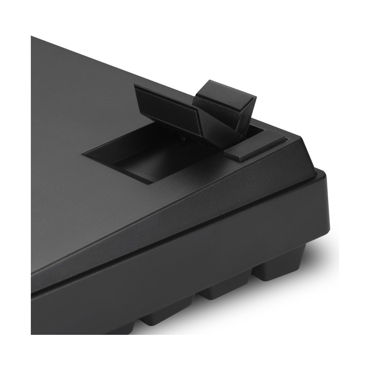 Zbliżenie na tył czarnej klawiatury z podniesioną, regulowaną podstawką.