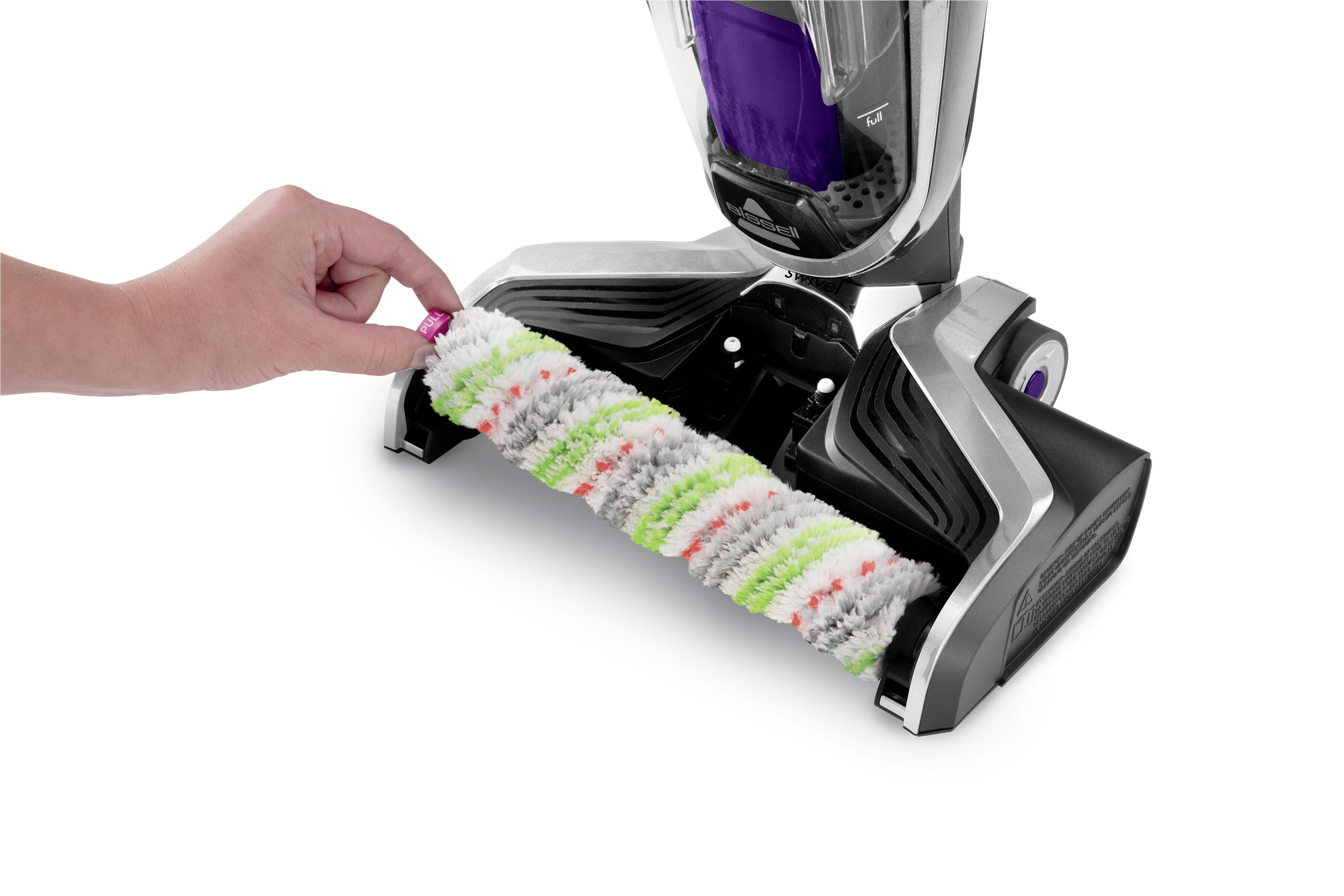 Die Hand einer Person entfernt eine Walzenbürste von einem Staubsauger.