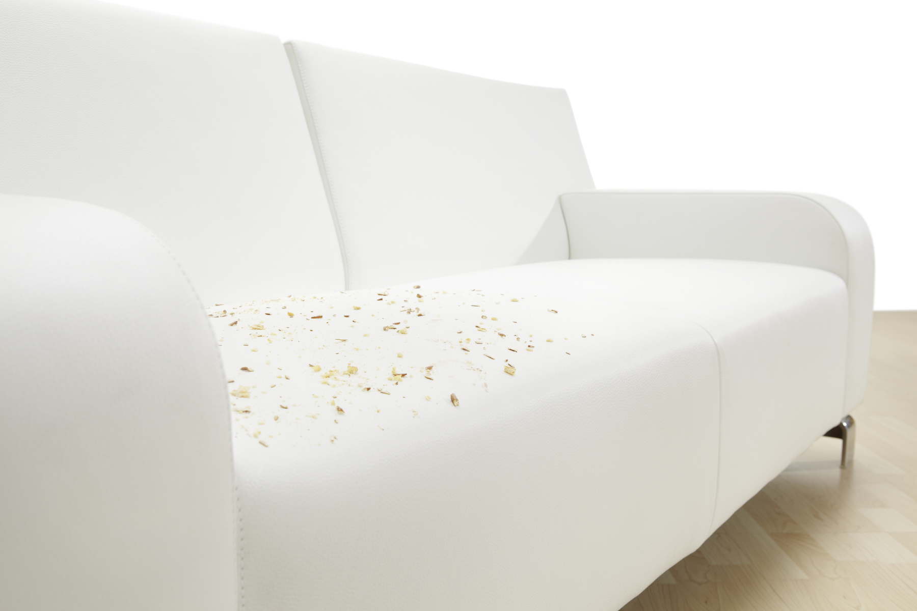 Ein weißes Sofa mit Holzspänen auf dem Sitz. Der Hintergrund ist weiß.