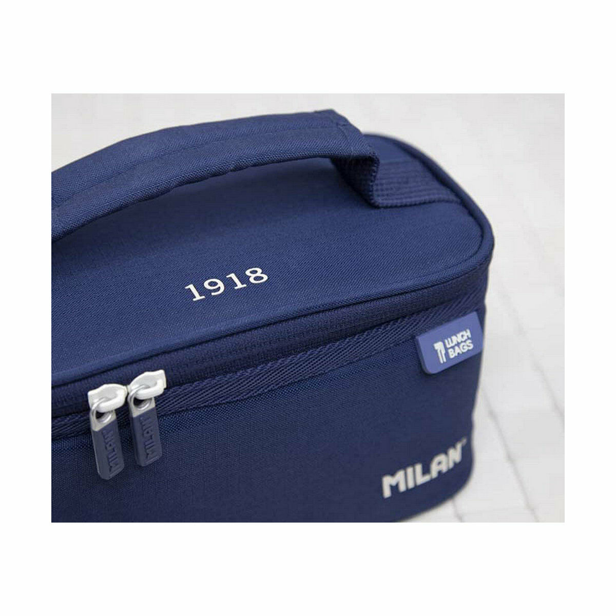 Marineblaue Lunchtasche mit weißem Text '1918' und 'MILAN'. Silberne Reißverschlüsse und ein Griff.