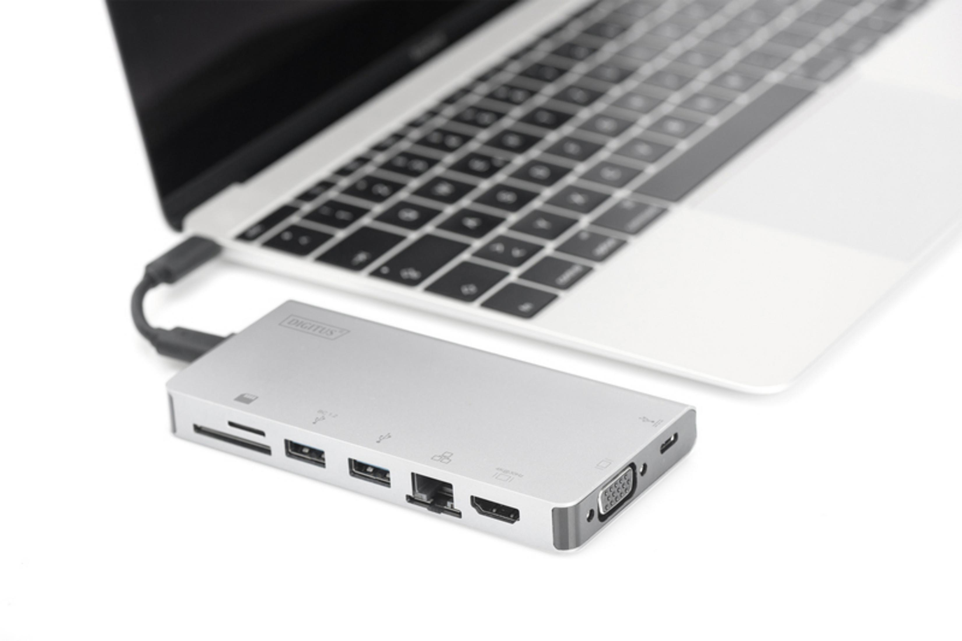 Un hub USB-C argentato con più porte collegato a un laptop.