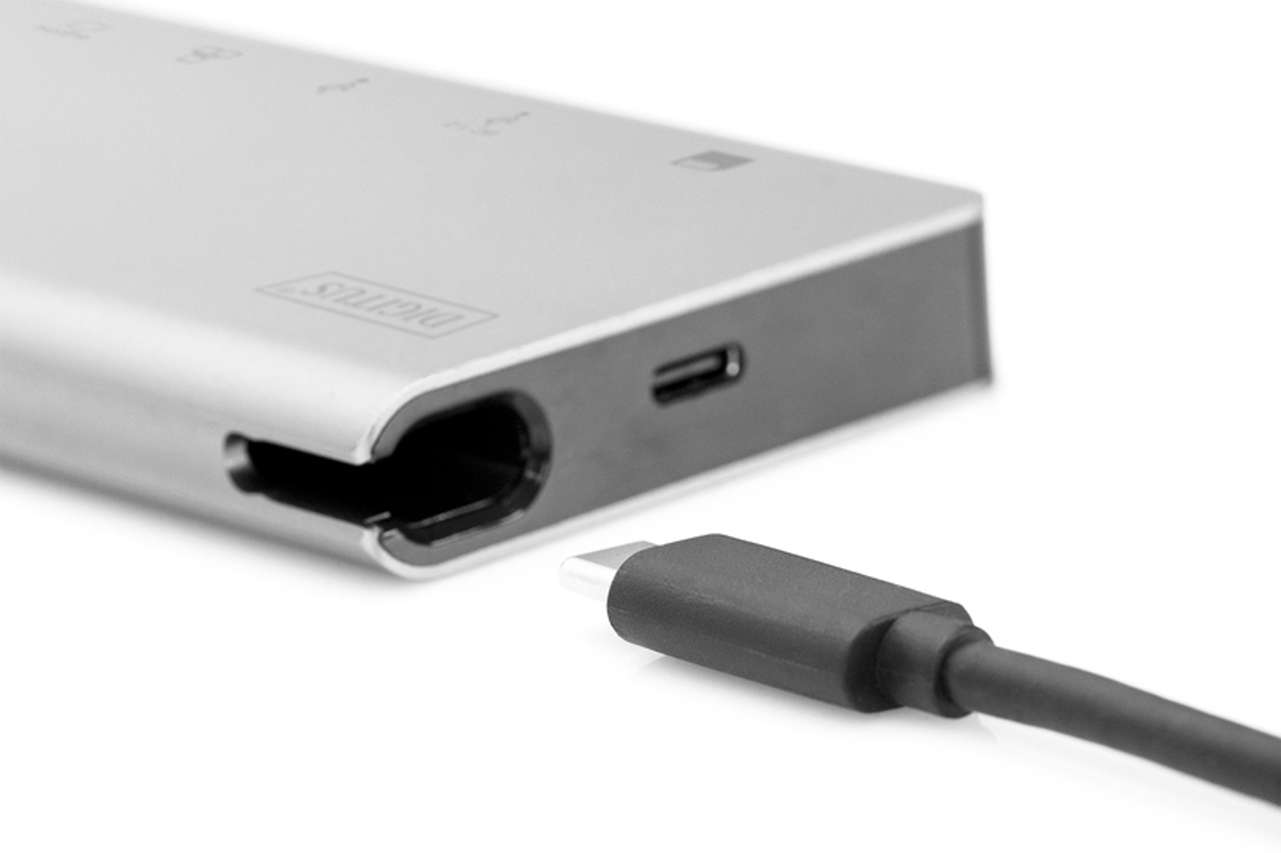 Un dispositivo argentato con una porta USB e un cavo nero collegato, sfondo bianco.