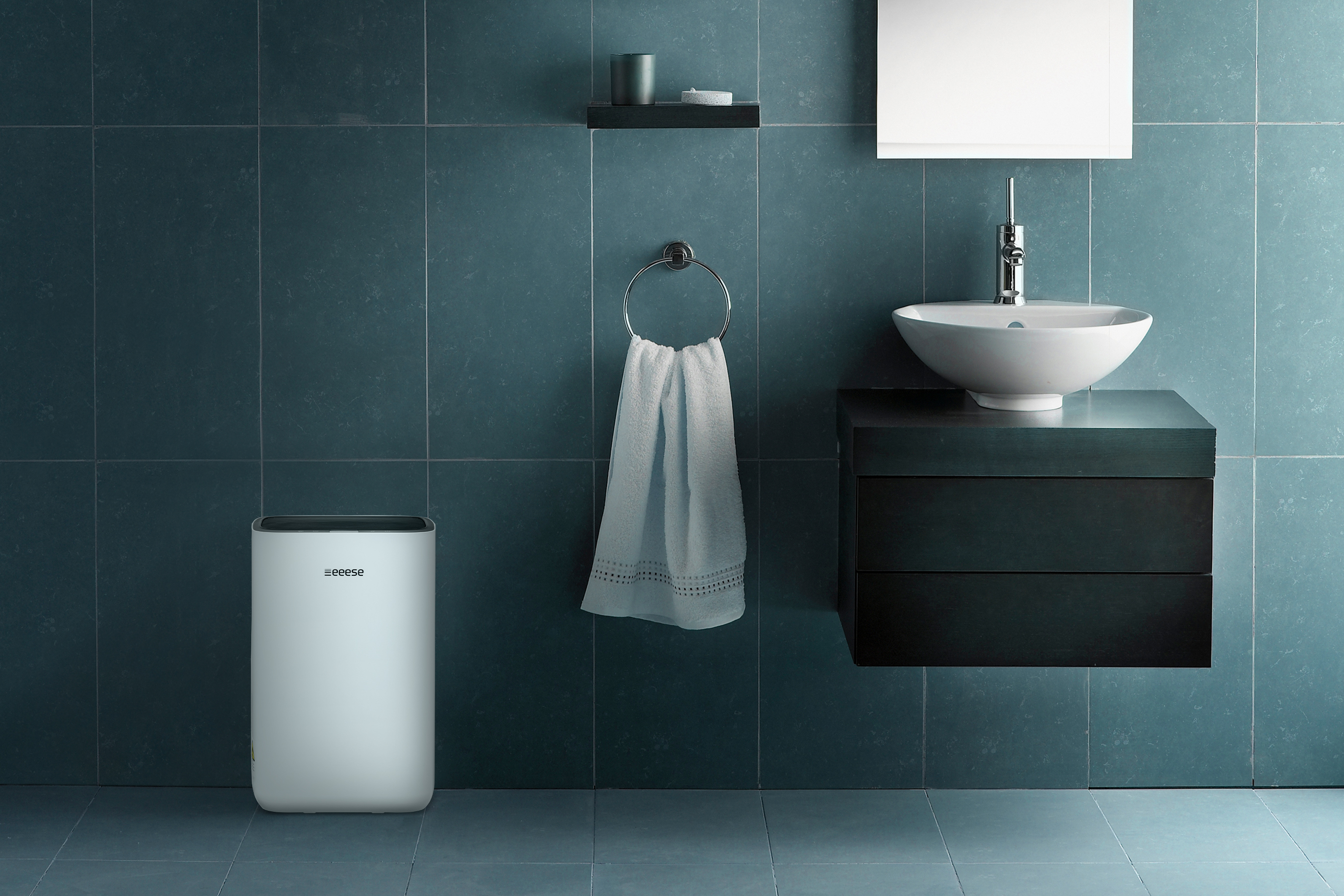 Badezimmer mit weißem Luftreiniger, Handtuch und Spiegel.