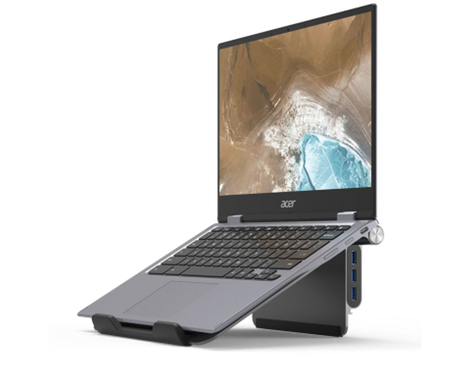 Laptop su un supporto, tastiera visibile, schermo con paesaggio.