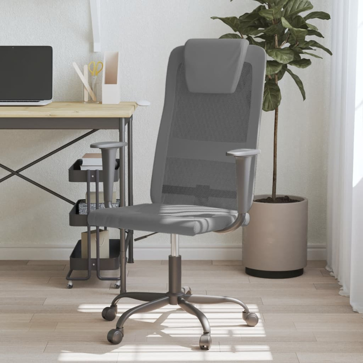 Grauer Bürostuhl aus Mesh, neben einem Schreibtisch mit Laptop und Pflanze.